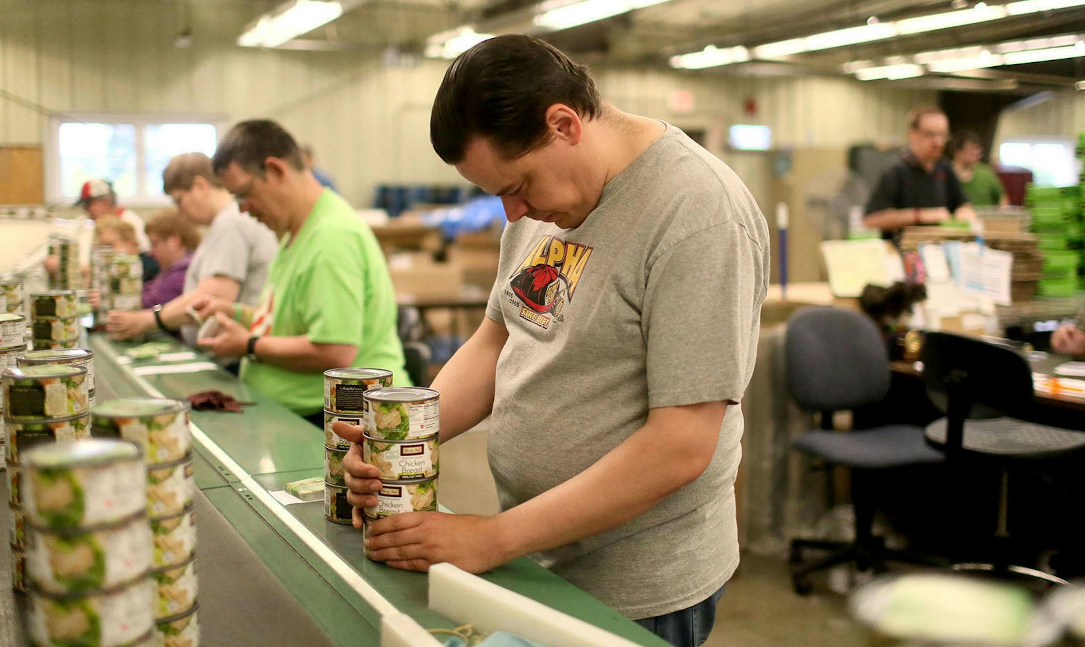 Dustin Leibfried, 42, who has worked for MRCI for three years, stacks cans of chicken on a fast-moving conveyor belt and packager known as the ìT-Rexî Thursday, June 4, 2015, at MRCI in Fairmont, MN. ìBecause there are some days when you feel like youíre just racing, racing to catch up, and they arenít paying us what they should be paying us. Most of us want out.î](DAVID JOLES/STARTRIBUNE)djoles@startribune.com Across Minnesota, thousands of disabled adults toil in