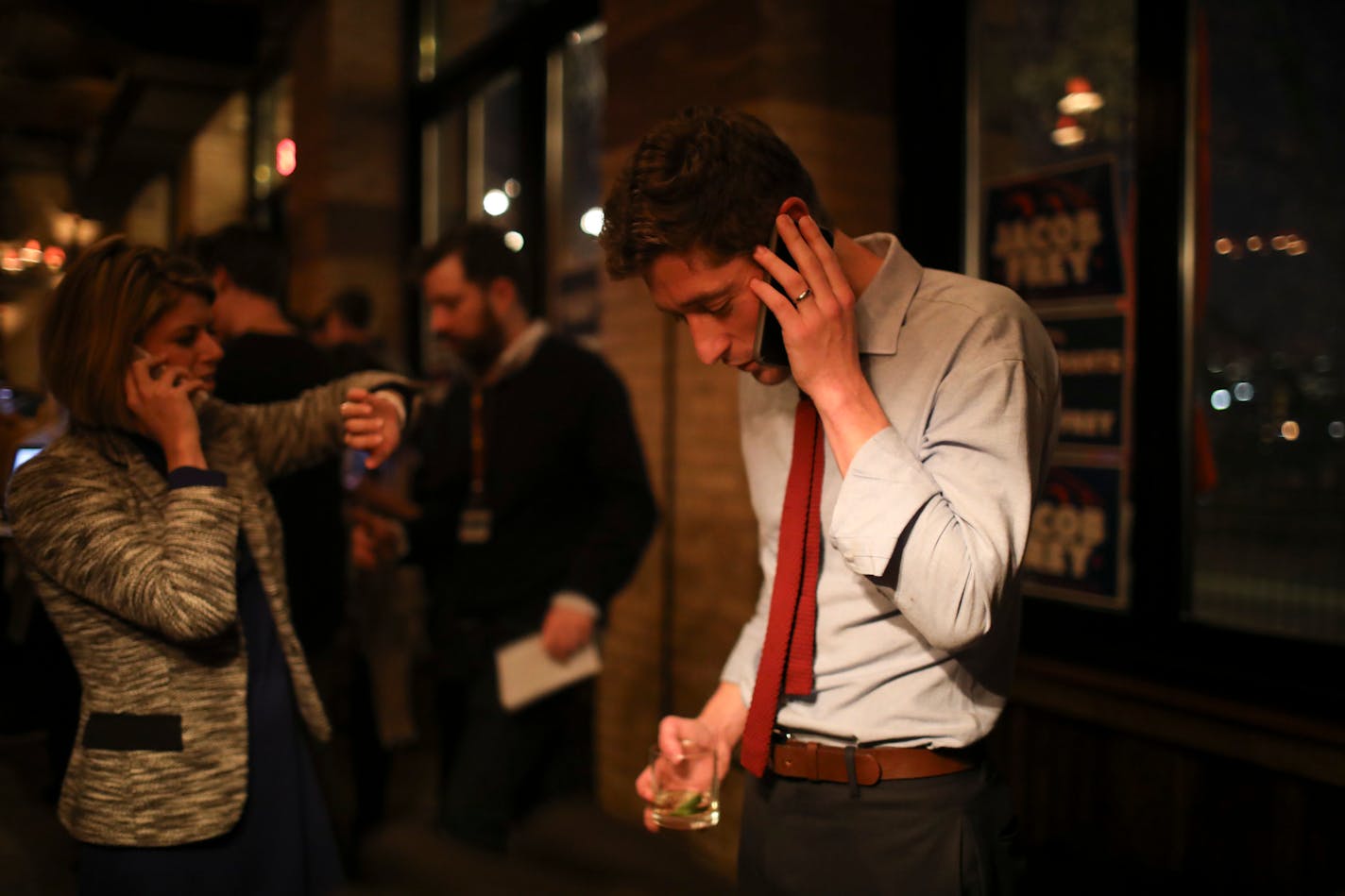 Jacob Frey took a phone call at his election night party. His communications director, Laura Monn Ginsburg was at left.