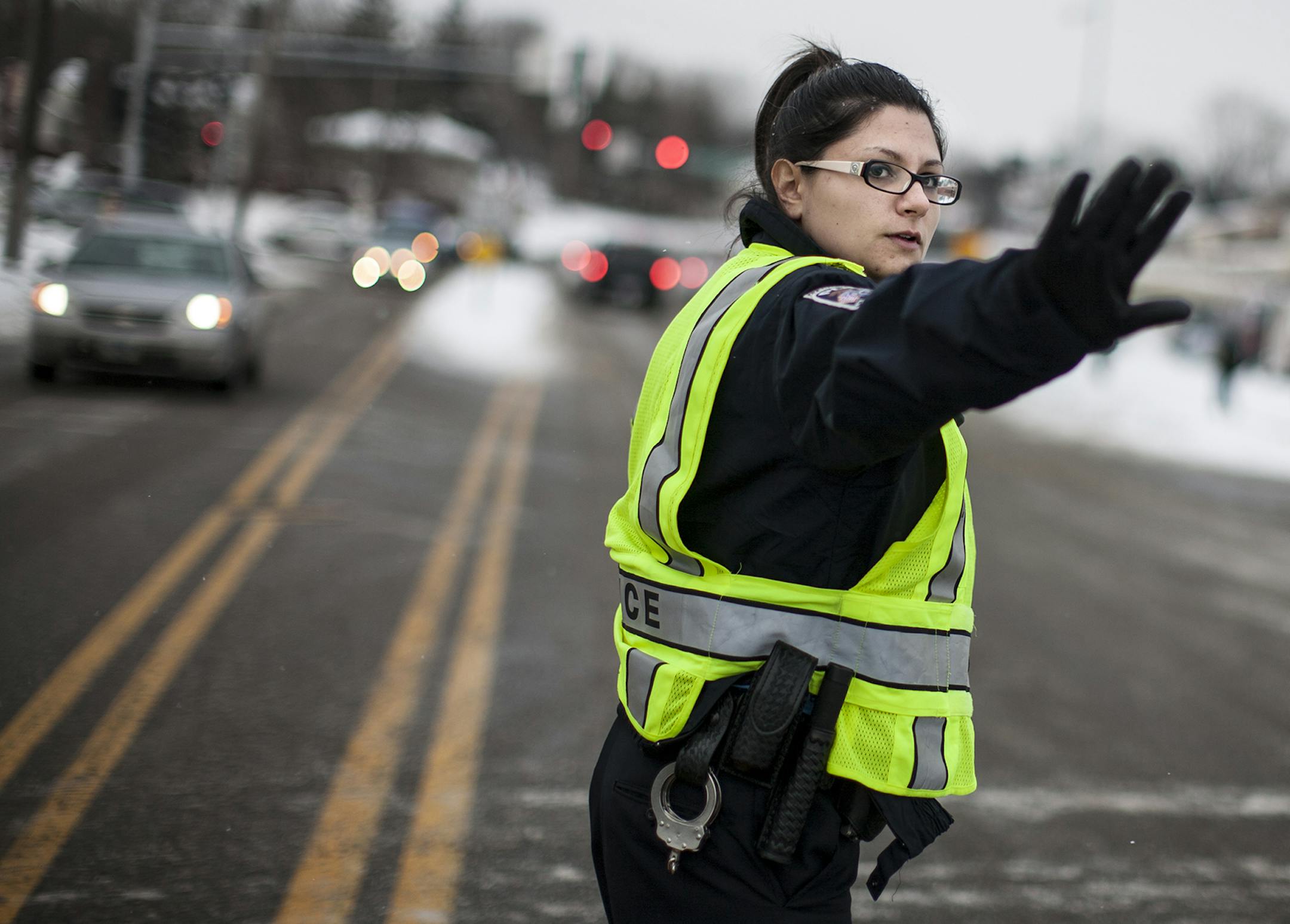 Community service officer Jackie Duchschere directs traffic after school for Valley View Elementary School and Columbia Academy on 49th Avenue NE in Columbia Heights December 20, 2013. She will become a full-time police officer with the city's police department next month, pending background and physical assessments. She has a bachelor's degree and experience in state government and says communication skills will be an important part of her job. (Courtney Perry/Special to the Star Tribune)