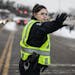 Community service officer Jackie Duchschere directs traffic after school for Valley View Elementary School and Columbia Academy on 49th Avenue NE in C