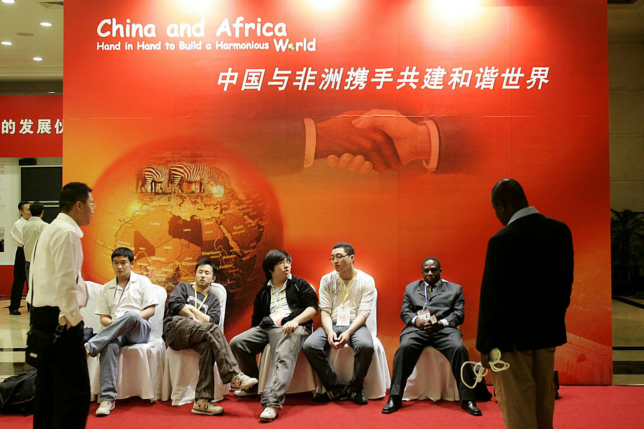 Chinese and African journalists wait to start the opening ceremony of the African Development Bank's annual meetings Wednesday May 16, 2007 in Shanghai, China. China has already forgiven more than US$1 billion in debt to it held by African countries, and is estimated to have provided billions of dollars (euros) in aid to the continent. Meanwhile, China's total investment in Africa, reported by the government at US$11.7 billion, is growing quickly as Chinese companies buy up stakes in oil and gas