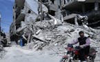 A man rides past destruction in the town of Douma, the site of a suspected chemical weapons attack, near Damascus, Syria, Monday, April 16, 2018. Fais