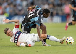 Minnesota United forward Bongokuhle Hlongwane (21) gets tripped up by Vancouver midfielder Ryan Gauld (25), resulting in a yellow card during the firs