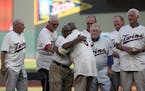 Joe Nossek receives a hug from Tony Oliva during a ceremony honoring the Minnesota Twins' 1965 team before a game against the Seattle Mariners at Targ