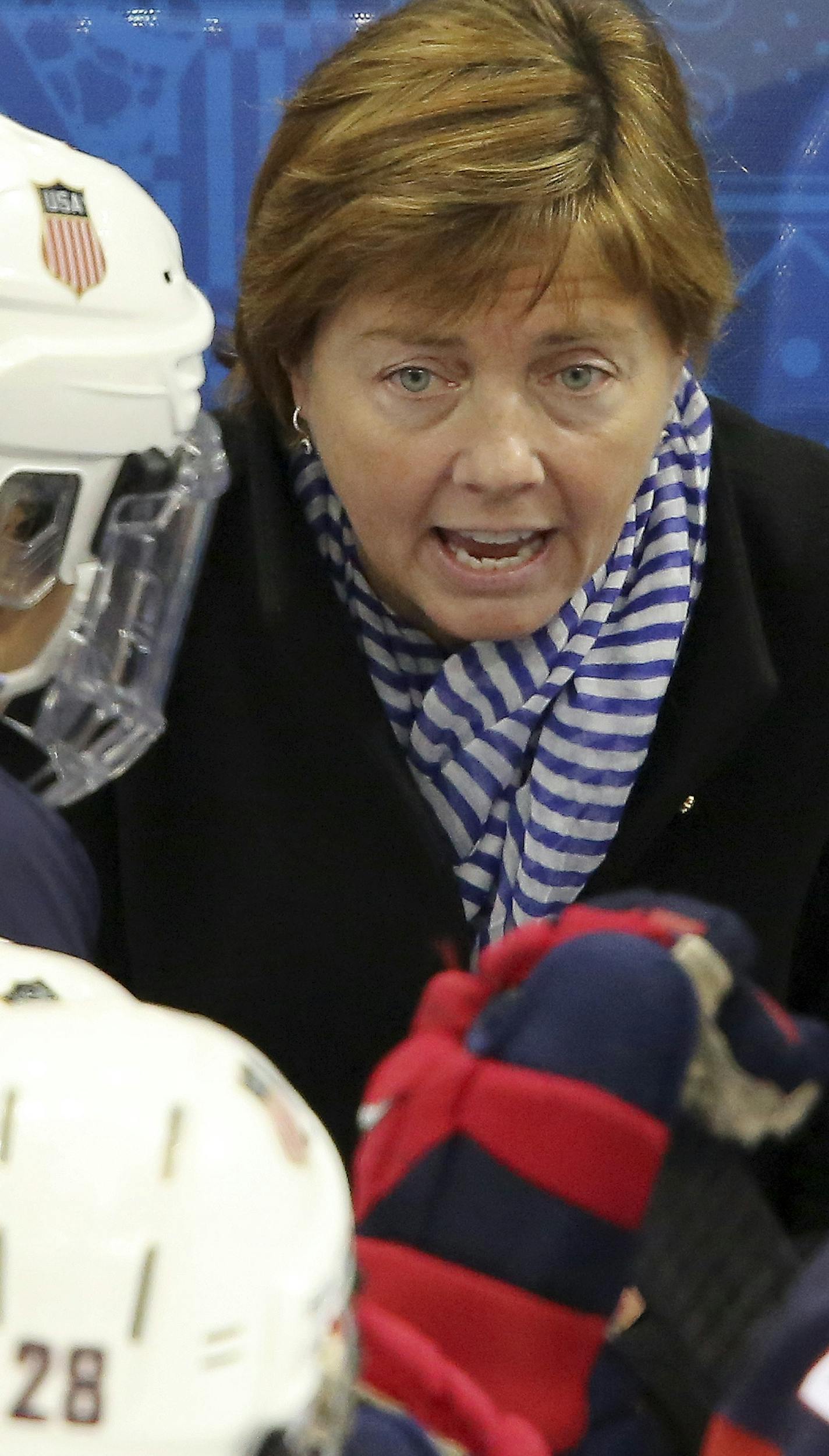 USA head coach Katey Stone talks to the team during a break in the action at the 2014 Winter Olympics women's ice hockey game between Canada and the United States at Shayba Arena, Wednesday, Feb. 12, 2014, in Sochi, Russia. (AP Photo/J. David Ake)