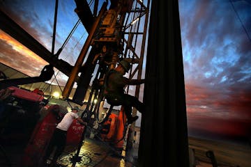 Derrick hand Scott Berreth (right) rappelled through the drilling rig structure as the crew prepared to restart machinery after some repairs had been 