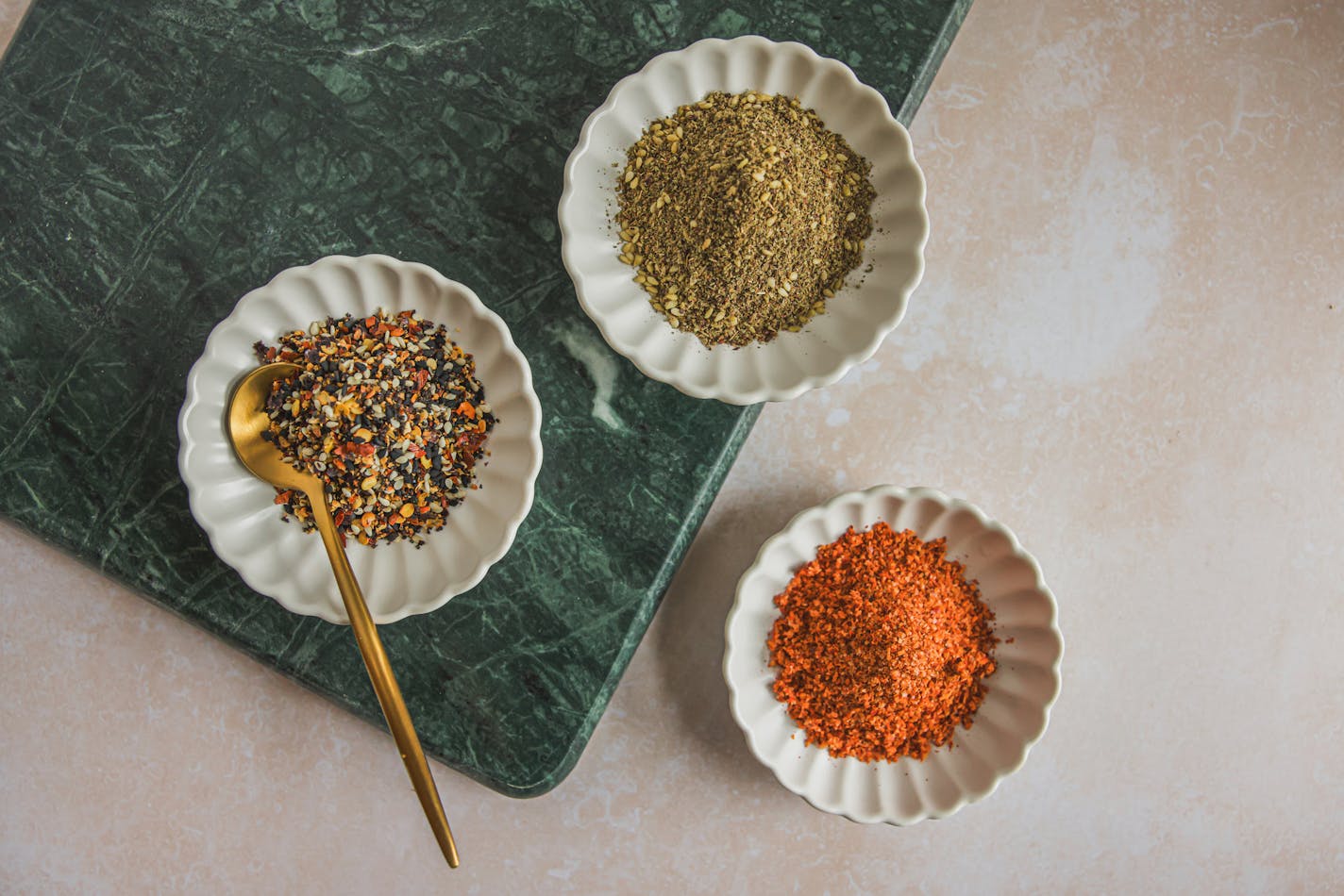 Three small bowls with homemade spice mixes -- shichimi togarashi, chile-lime seasoning and za'atar.