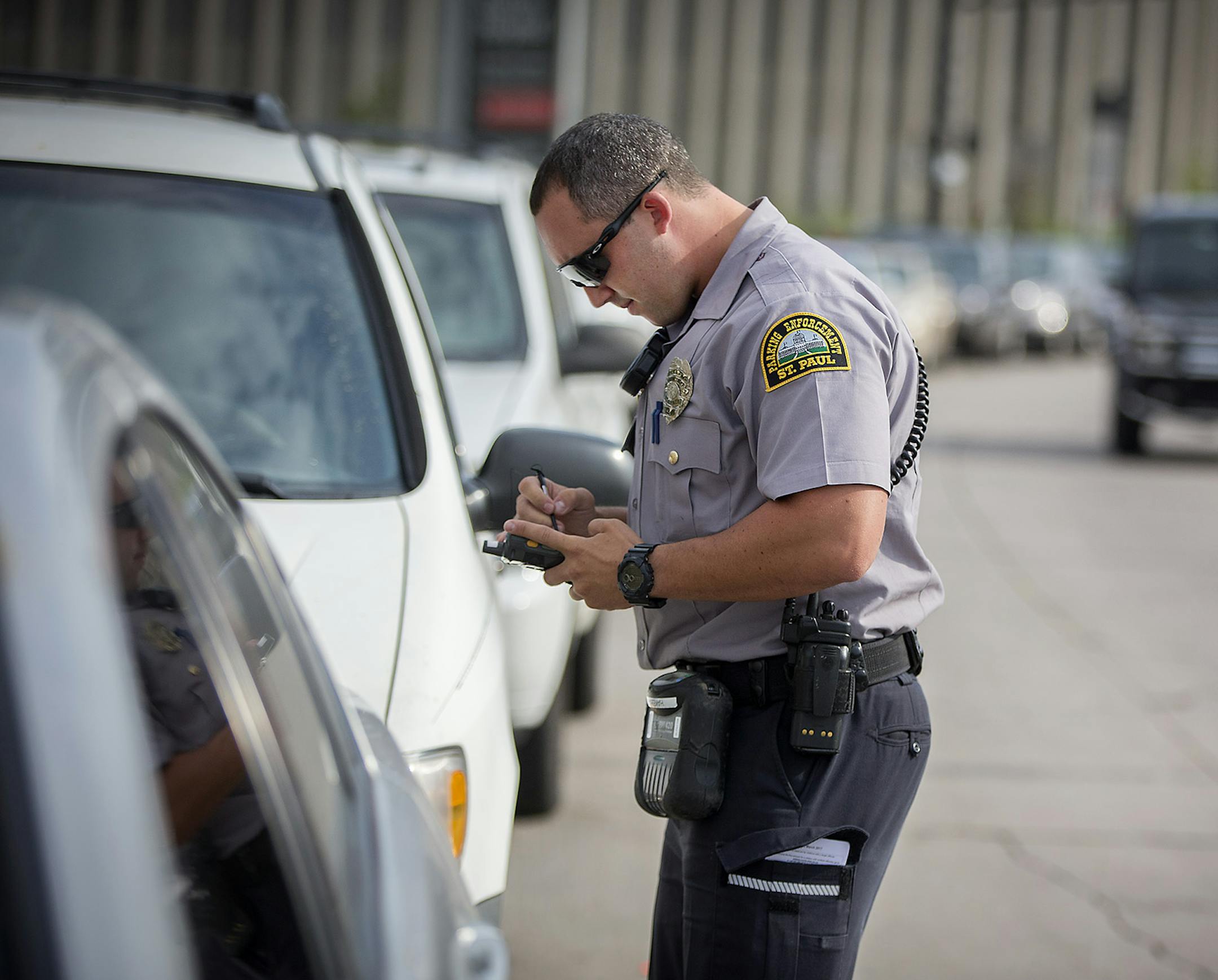 St. Paul Parking Enforcement Officer Joe Hakeem wrote up parking tickets to a couple of cars that were parked in a turn lane near Regions Hospital making it difficult for ambulances to turn, Wednesday, July 11, 2018 in St. Paul, MN. ] ELIZABETH FLORES ï liz.flores@startribune.com