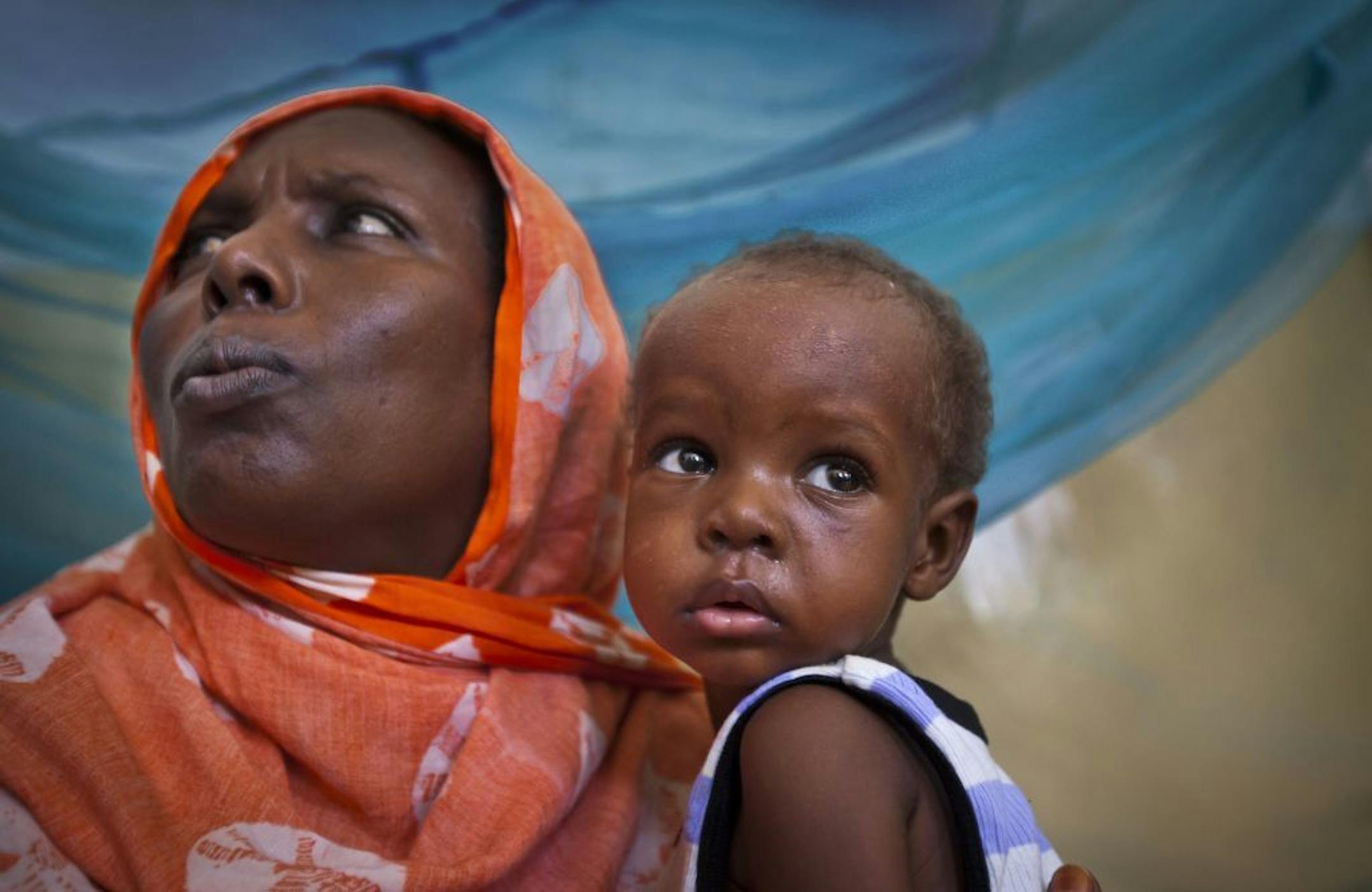 April 24, 2013: Saqa Farah, the mother of 12 children from a nomadic goat herding family in northern Somalia, holds her 1-year-old baby Abdi Noor Hussein who is suffering from measles.