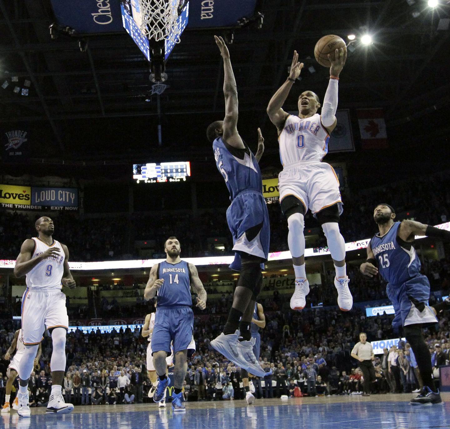 Oklahoma City Thunder guard Russell Westbrook (0) shoots in front of teammate Serge Ibaka (9), and Minnesota Timberwolves center Nikola Pekovic (14), center Gorgui Dieng (5) and guard Mo Williams (25) in the first quarter of an NBA basketball game in Oklahoma City, Monday, Jan. 26, 2015. (AP Photo/Sue Ogrocki)