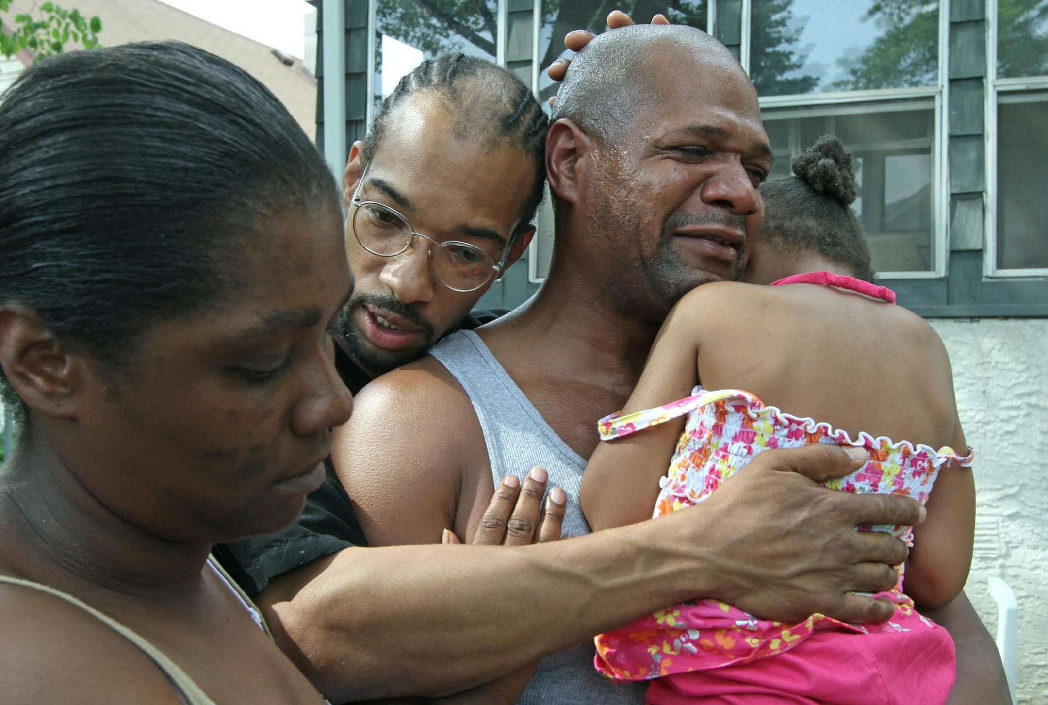Relatives of Tyrell Baymon, who was critically injured by a motorcyclist in St. Paul on his 4th birthday, comforted each other Saturday. From the left, they are: Janita Jones, Tyrell's aunt; Dennis Scroggins, his uncle; and Andre Scroggins, also an uncle, holding Tyrell's cousin Anjanee Scroggins.