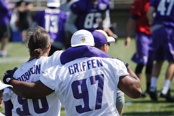Minnesota Vikings defensive ends Brian Robison, left, and Everson Greffen (97) share some brotherly love during training camp Friday, July 25, 2014, a
