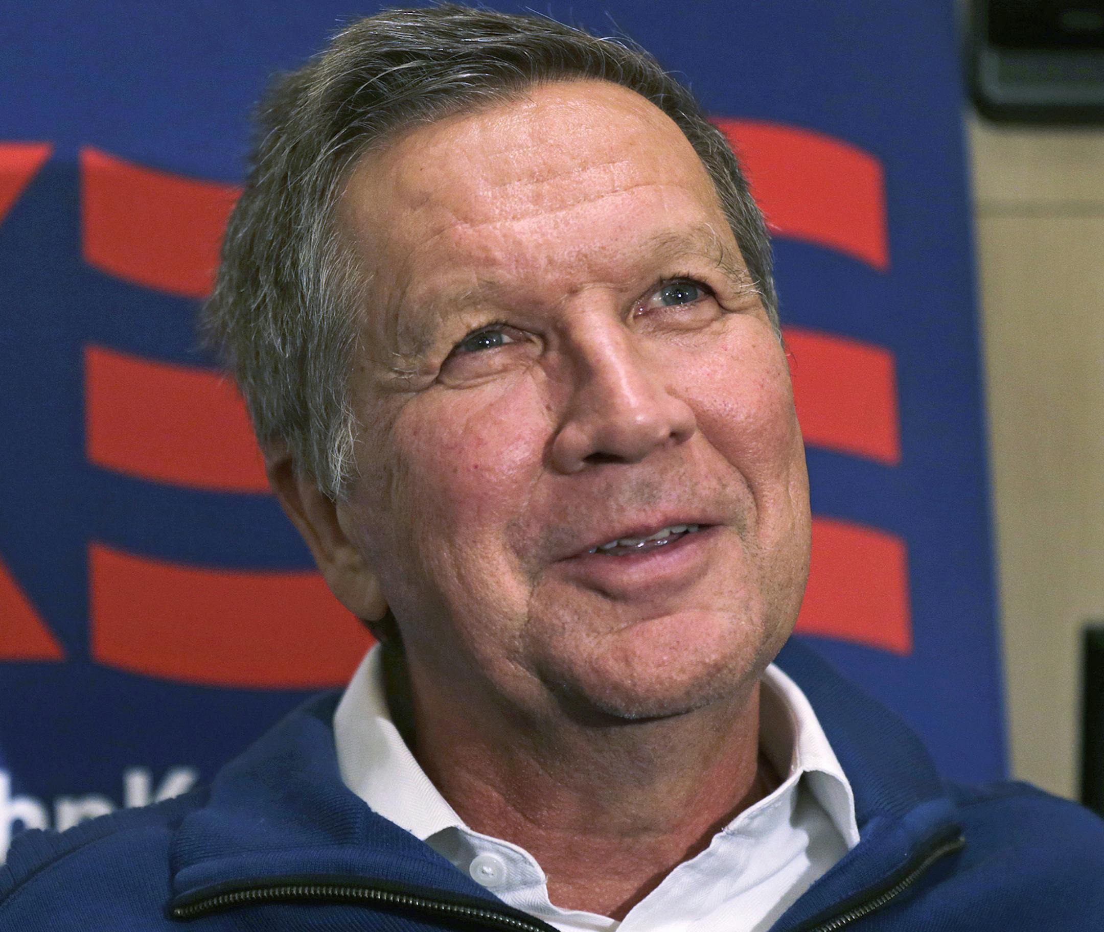 In this photo taken Jan. 20, 2016, Republican presidential candidate, Ohio Gov. John Kasich answers a question during an interview on his campaign bus in Bow, N.H. Kasich isn't angry. And he's betting his presidential aspirations that voters aren't, either, despite the sustained political strength of leading Republicans he says are taking the country "into the dark." (AP Photo/Charles Krupa) ORG XMIT: MIN2016012213470301