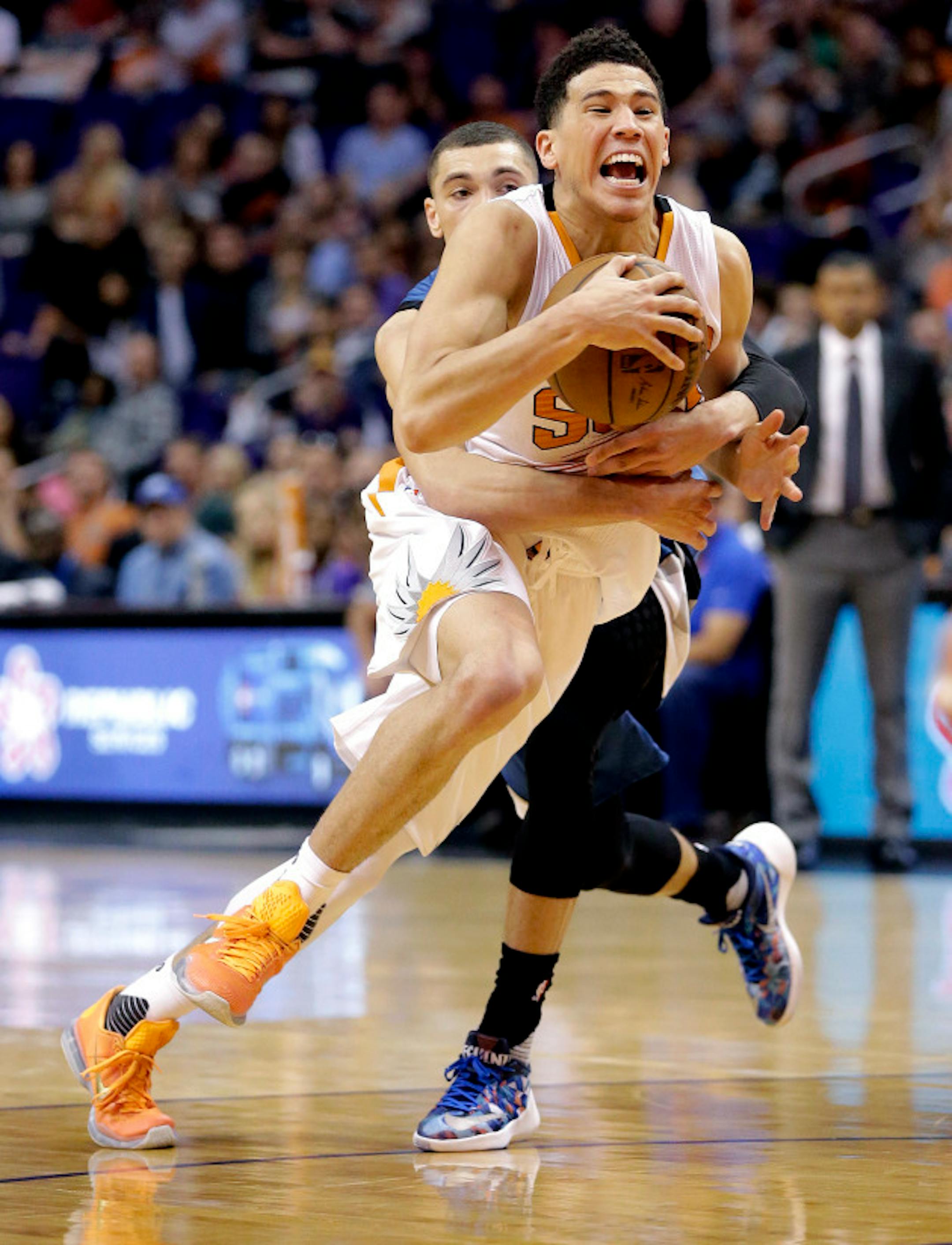 Phoenix Suns' Devin Booker, front, is fouled by Minnesota Timberwolves' Zach LaVine during the second half of an NBA basketball game, Monday, March 14, 2016, in Phoenix. The Suns won 107-104. (AP Photo/Matt York)