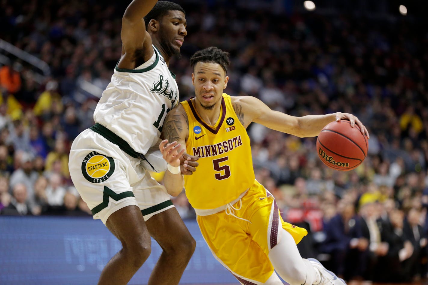 Minnesota's Amir Coffey drives past Michigan State's Aaron Henry during the NCAA tournament. Coffey soon will decide whether or not to fully declare for the NBA draft.