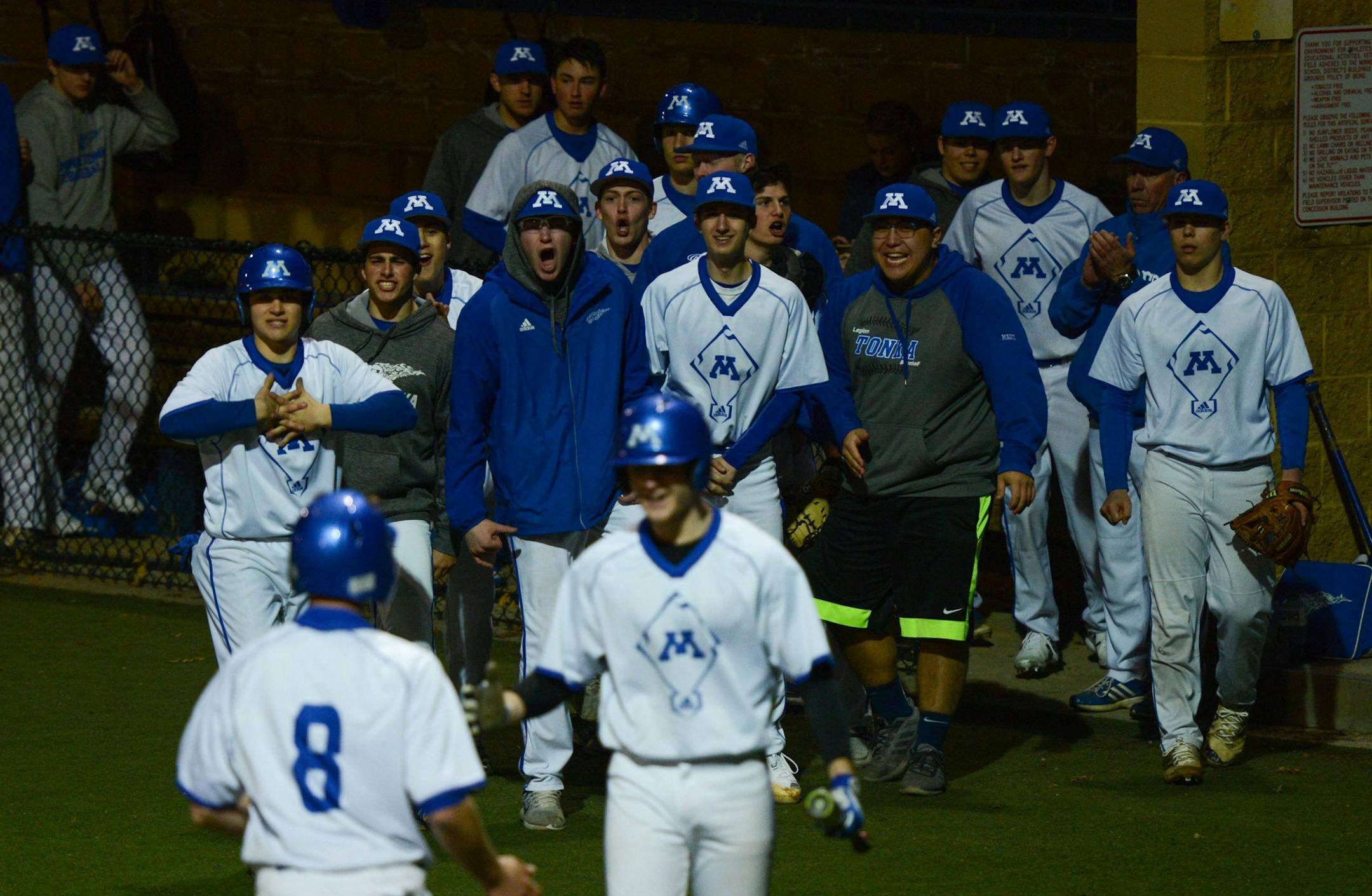 Minnetonka players congratulate teammate Ben Stolar after he scored a run during the Skippers' 5-2 victory over Eden Prairie on April 12. Photo: Carter Jones, SportsEngine
