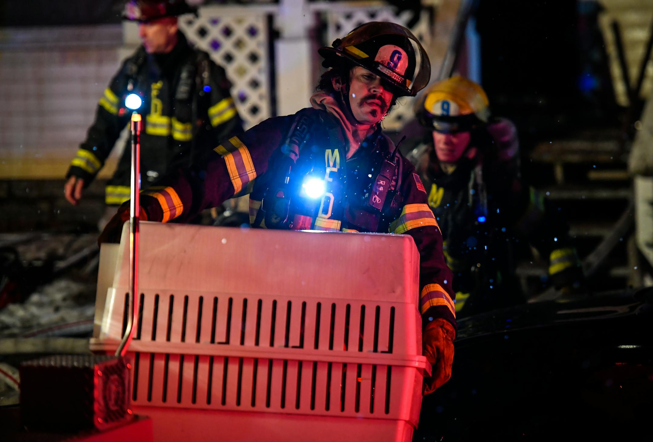 A firefighter emerged from a home on the 3000 block of Aldrich Avenue S. in the Uptown neighborhood Monday night carrying a kennel containing a dog, which appeared to be unharmed.