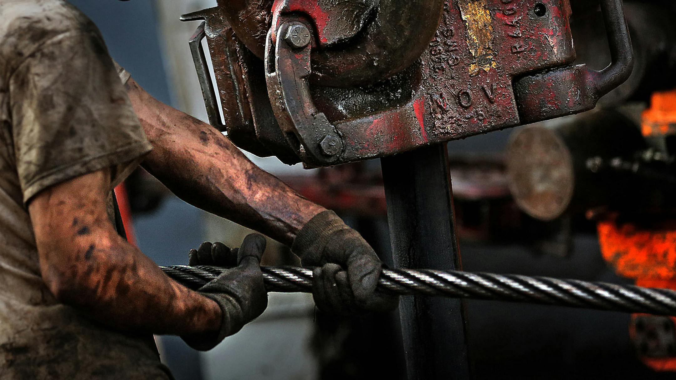 Floor hand Ray Gerrish worked to make repairs on a drilling rig as the sun rose near the site outside Watford City in October 2013.