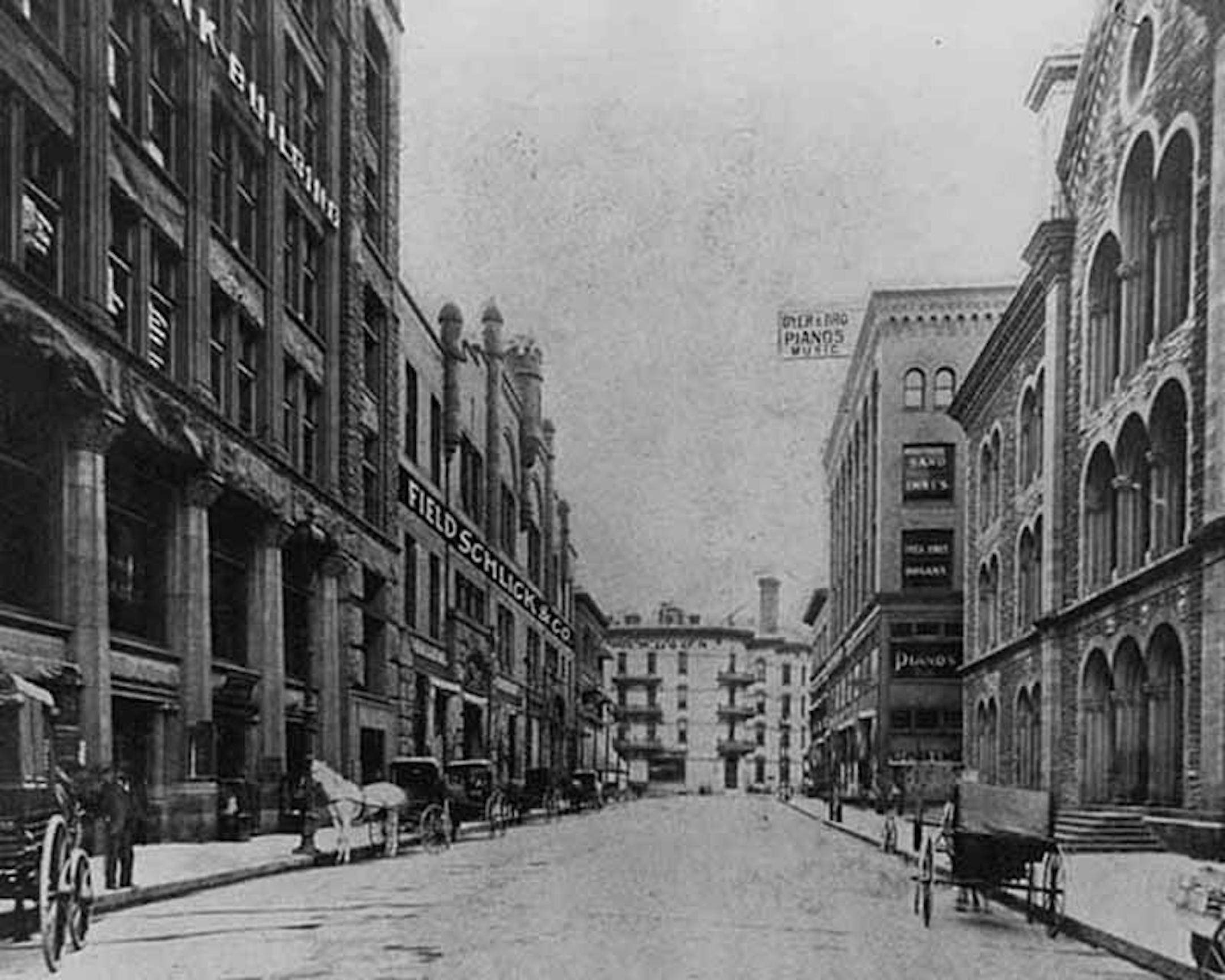 Fifth Street side of the Grand Arcade in about 1902, with a painted-on sign for the Field-Schlick store. To the left of the arcade is the Germania Bank (now St. Paul) Building, which still stands.