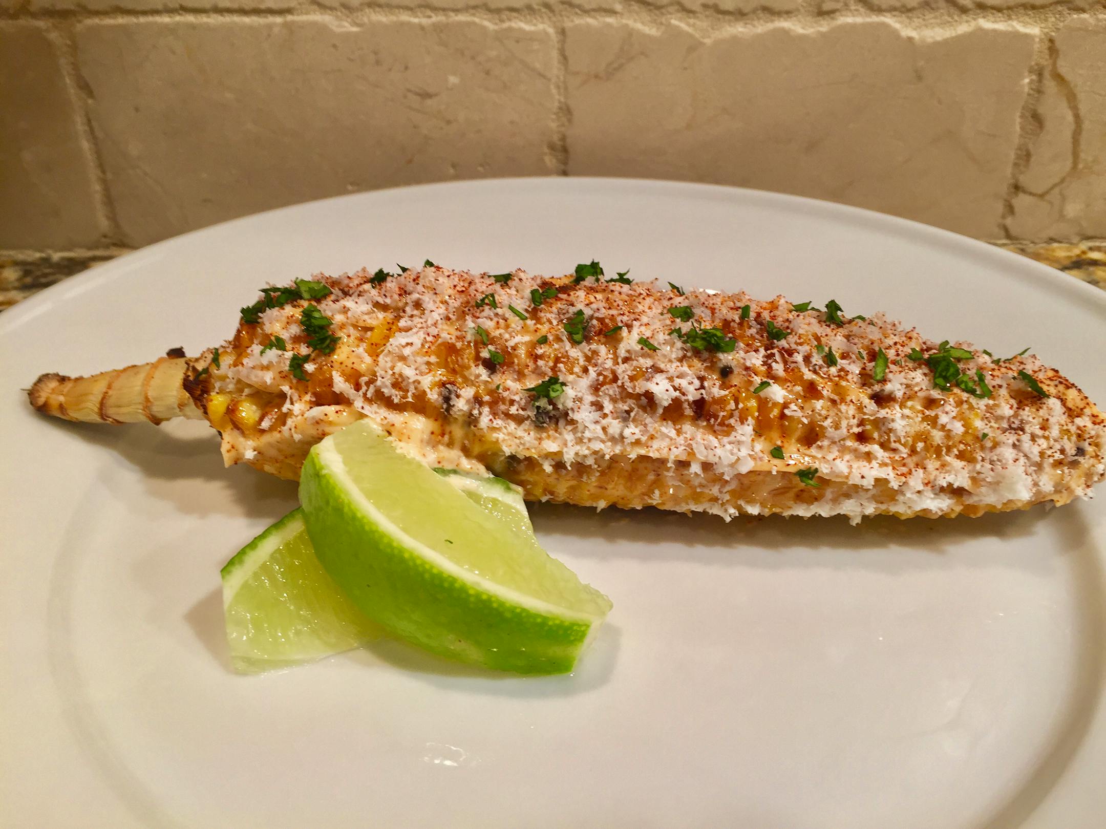 Wood-Grilled Elote: Corn on-the-cob grilled over an oak wood fire, brushed with chile-spiced mayo and sprinkled with queso Cotija & fresh lime juice. At Tejas Express, located on the north wall in The Garden.