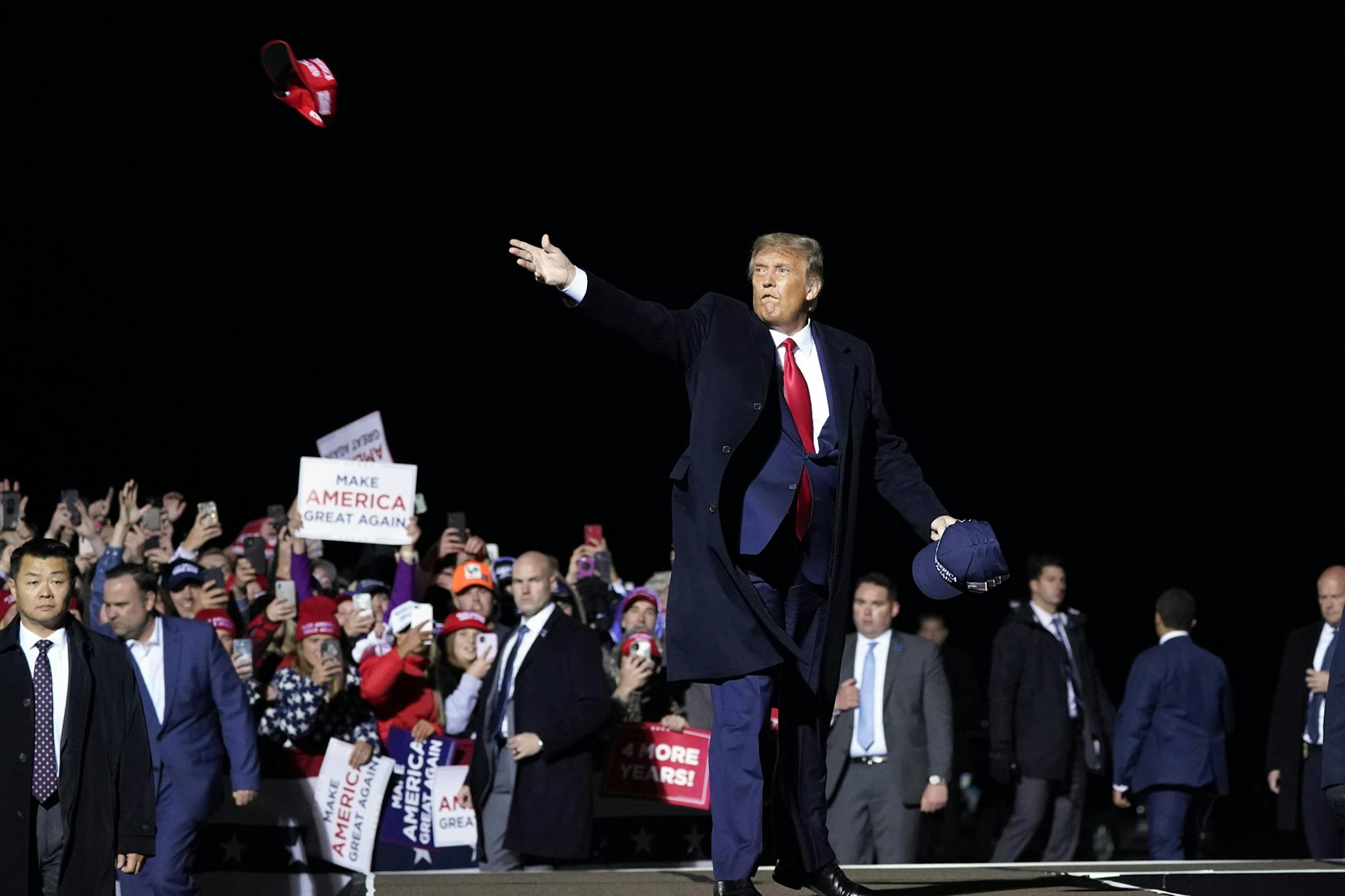 FILE - In this Wednesday, Sept. 30, 2020 file photo, President Donald Trump throws hats to supporters after speaking at a campaign rally at Duluth International Airport in Duluth, Minn. Trump's relentless cheerleading for the stock market, taking full credit for its gains, has been a hallmark of his presidency, through more than 150 tweets and soaring rhetoric at his rallies. Yet behind the bluster is a simple fact of which most voters are unaware: Trump barely has any of his own money in the st