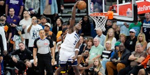 Anthony Edwards of the Wolves goes high over Kevin Durant of the Suns for a fourth quarter dunk.