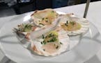 Scallops are served in seashells at Travail's Homage pop-up.