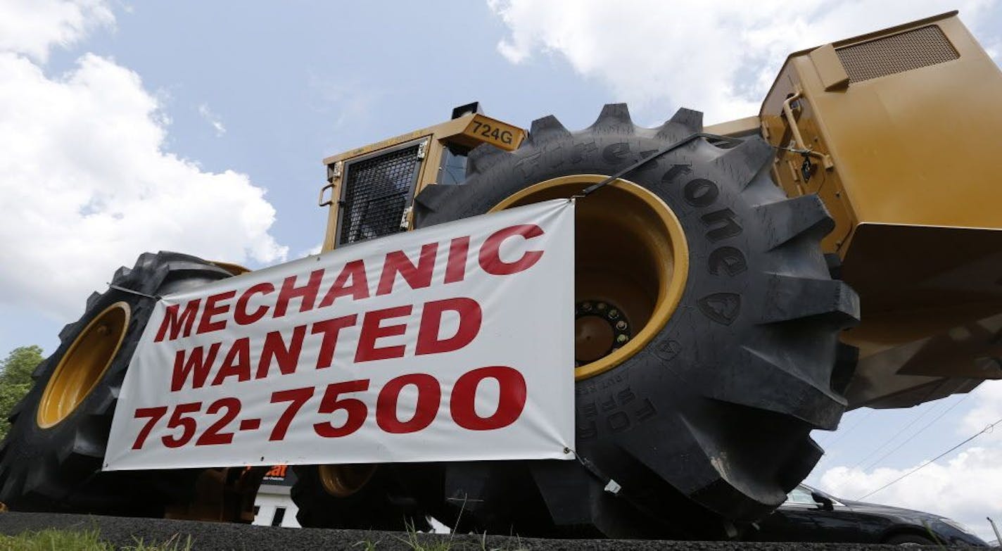 In this Tuesday, June 9, 2015 photo, a help wanted sign is posted at a tractor dealership in Ashland, Va.