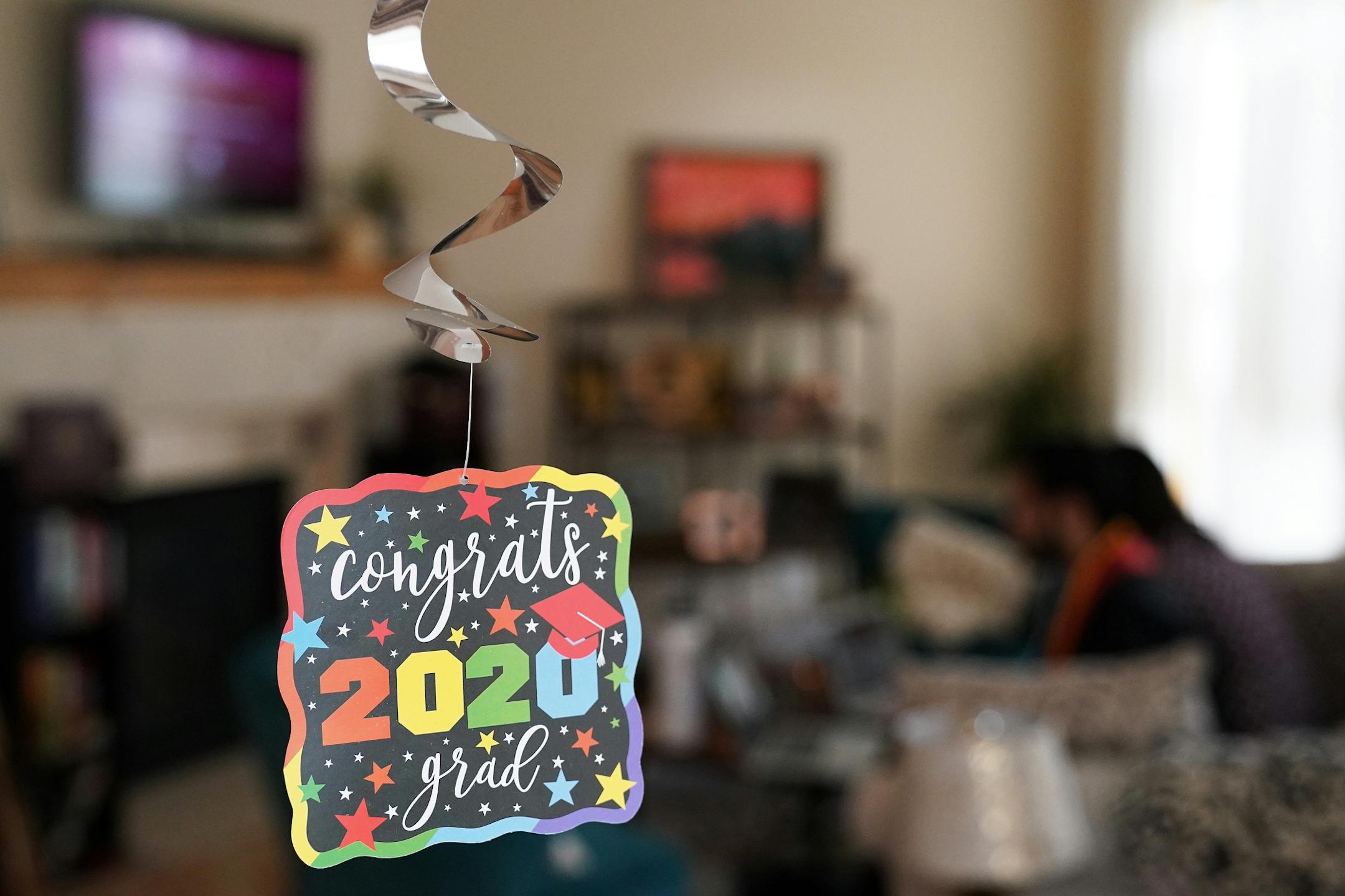 Decorations hung as Izaak Mendoza watched the video commencement address in his graduation robes alongside his wife Becky and his family who were on a video call from their home in Wyoming Saturday.