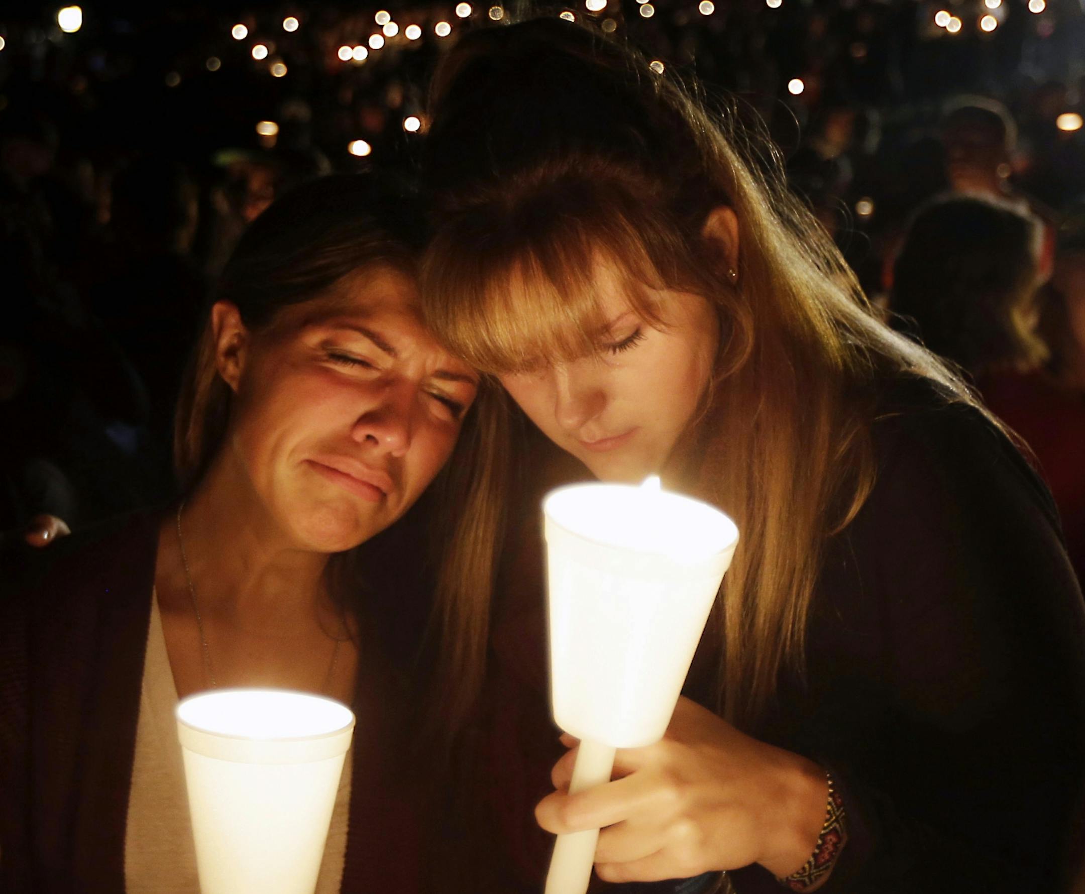 Kristen Sterner, left, and Carrissa Welding, both students at Umpqua Community College, embrace each other during a candlelight vigil for those killed during a shooting at the college, Thursday, Oct. 1, 2015, in Roseburg, Ore.