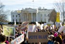 Women's March demonstrators walk past the White House in Washington, Saturday, Jan. 20, 2018. On the anniversary of President Donald Trump's inaugurat