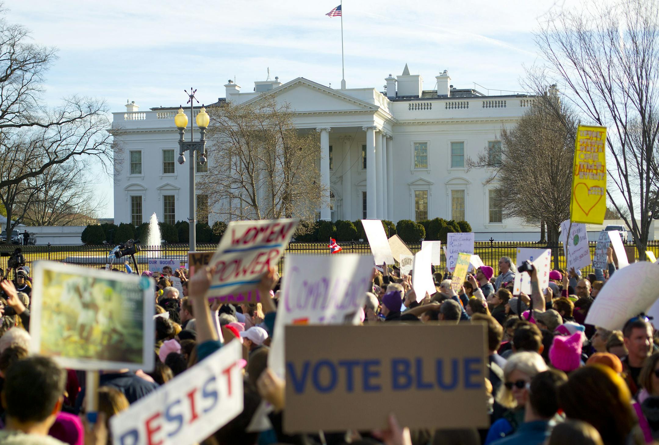 Women's March demonstrators walk past the White House in Washington, Saturday, Jan. 20, 2018. On the anniversary of President Donald Trump's inauguration, people participating in rallies and marches in the U.S. and around the world Saturday denounced his views on immigration, abortion, LGBT rights, women's rights and more. (AP Photo/Pablo Martinez Monsivais)