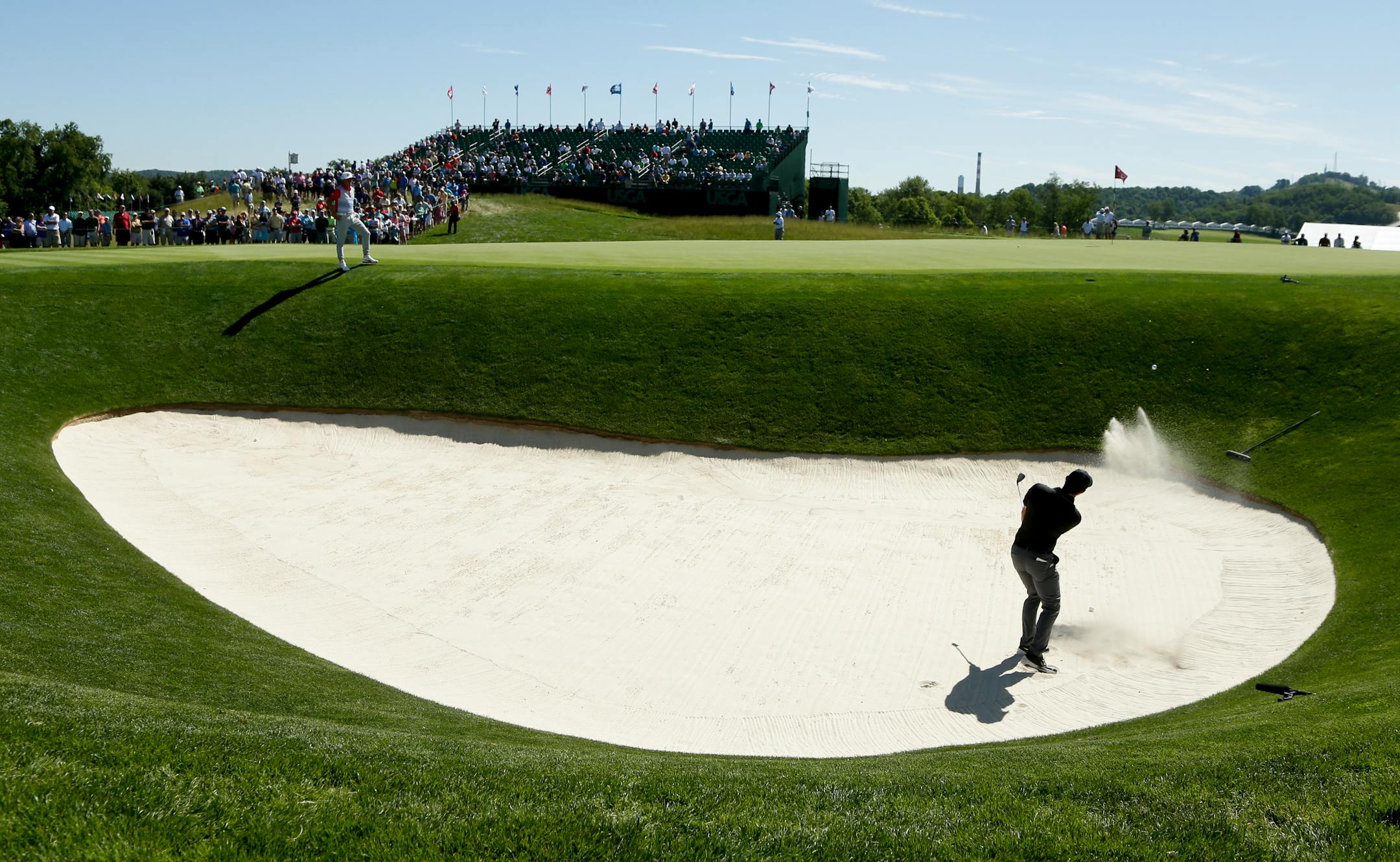 Rory McIlroy, of Northern Ireland, hits out of the bunker on the 17th hole during a practice round for the U.S. Open golf championship at Oakmont Country Club on Tuesday, June 14, 2016, in Oakmont, Pa. (AP Photo/Charlie Riedel)