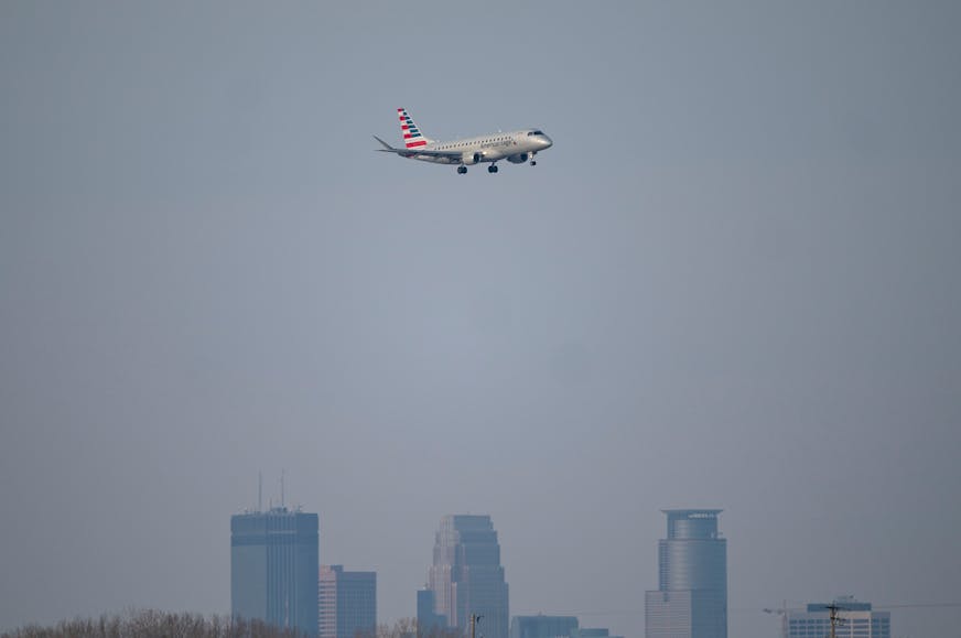 An American Airlines commercial airliner lands over the Minneapolis skyline at Minneapolis-St. Paul International Airport Tuesday, Dec. 14, 2021 in Minneapolis, Minn. Officials at the Minneapolis-St. Paul International Airport and the Transportation Security Administration are predicting a brisk Christmas travel season, despite the spread of COVID variants in Minnesota. ] ALEX KORMANN • alex.kormann@startribune.com