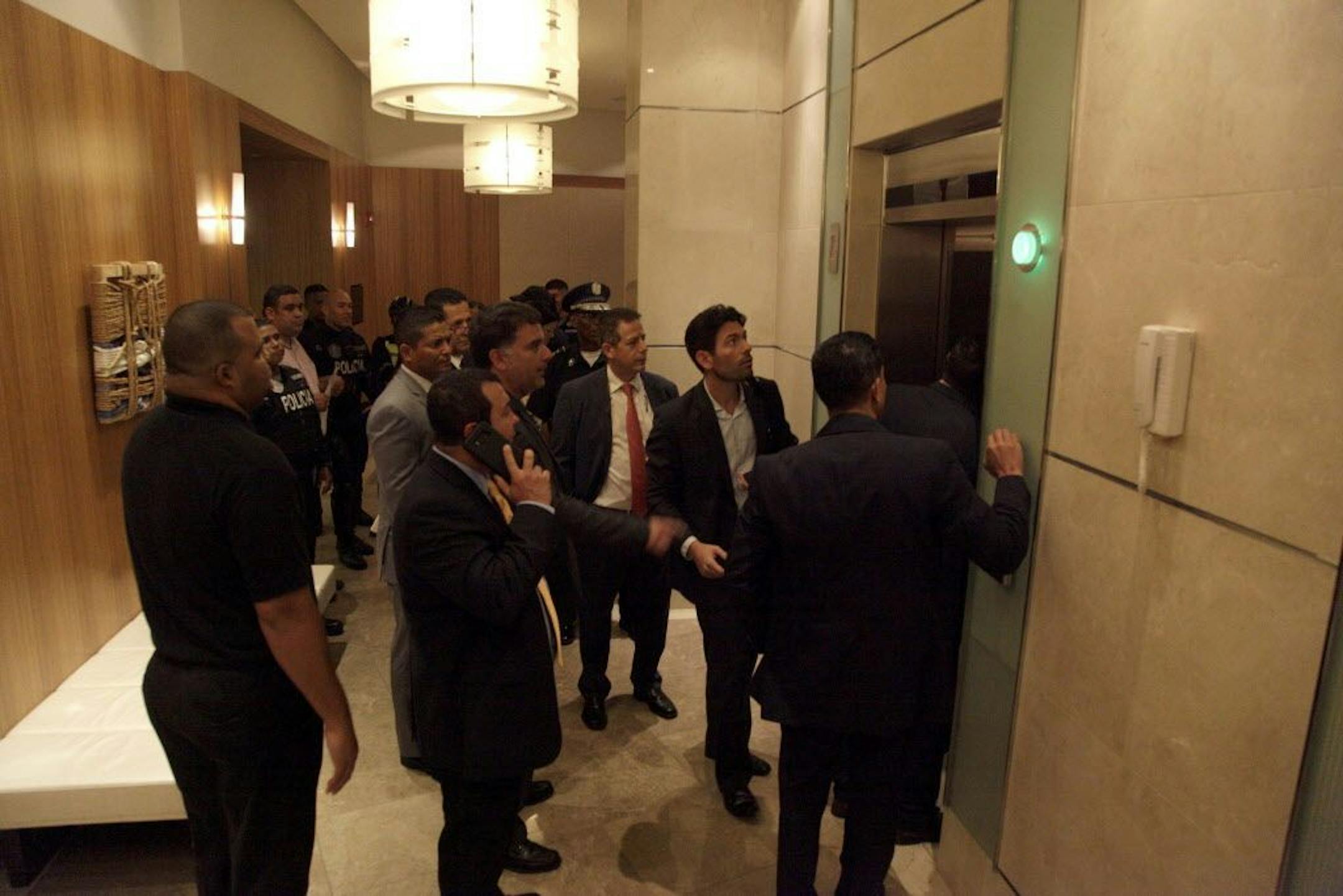 Orestes Fintiklis, second right, manager of the Miami-based private equity fund Ithaca Capital, walks into an elevator along with police officers, in the Trump Ocean Club International Hotel and Tower in Panama City, Monday, March 5, 2018. Escorted by police officers and a Panamanian judicial official, the owner of the Trump Panama City hotel has taken control of the property. A team of Trump security officials left the property.