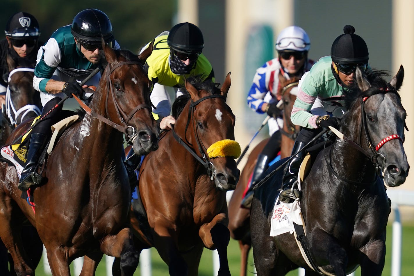 Jockey Jareth Loveberry, center in mask, rode Summer Assault to victory in the Mystic Lake Derby at Canterbury Park.