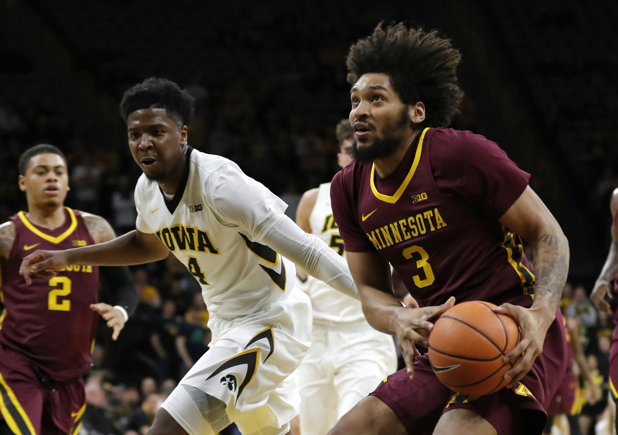Minnesota forward Jordan Murphy (3) drives to the basket past Iowa guard Isaiah Moss, left, during the first half of an NCAA college basketball game, Tuesday, Jan. 30, 2018, in Iowa City, Iowa.