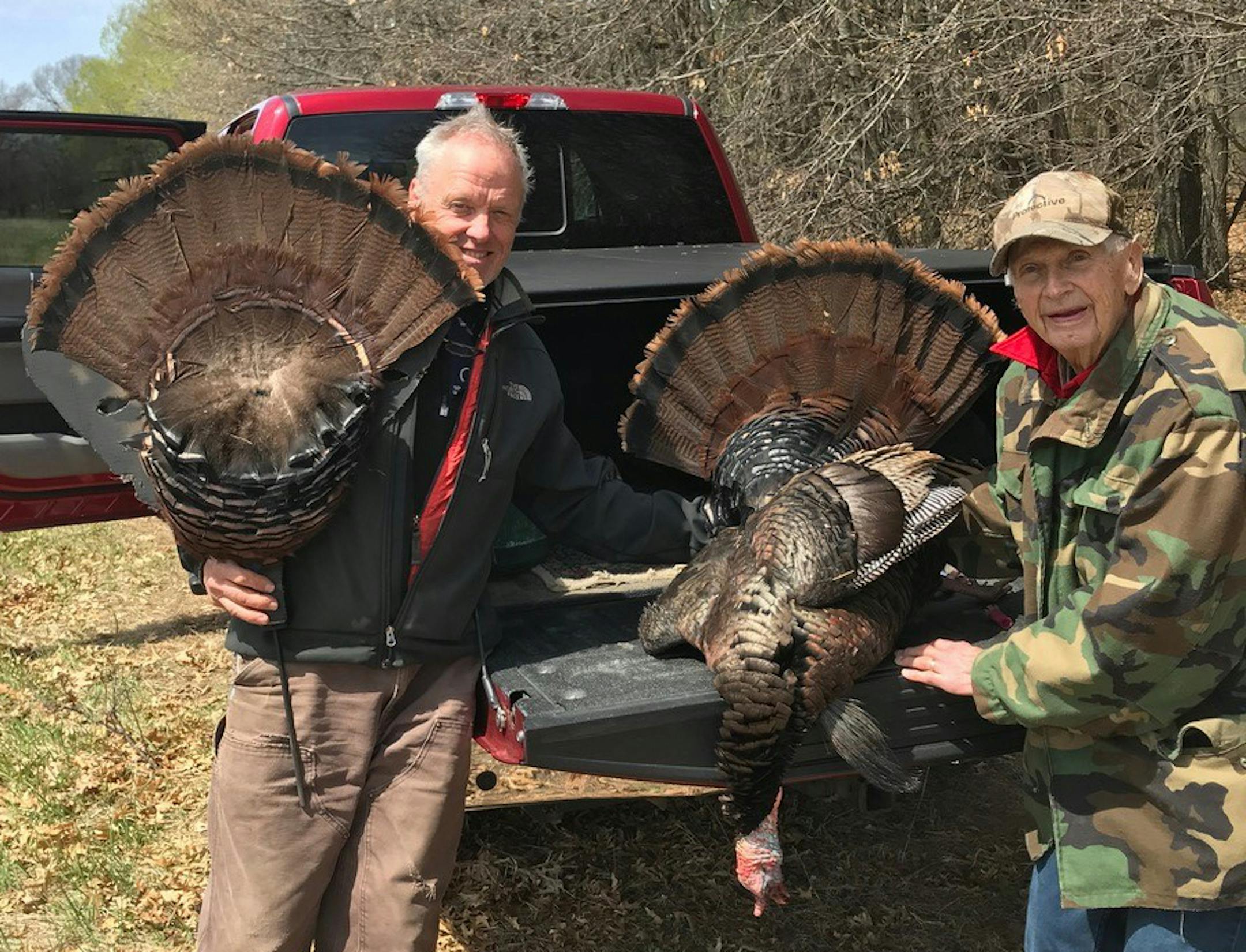 Tom Anderson, left, with the tail feathers he used to help his father, David Conger, 93, bag a gobbler.