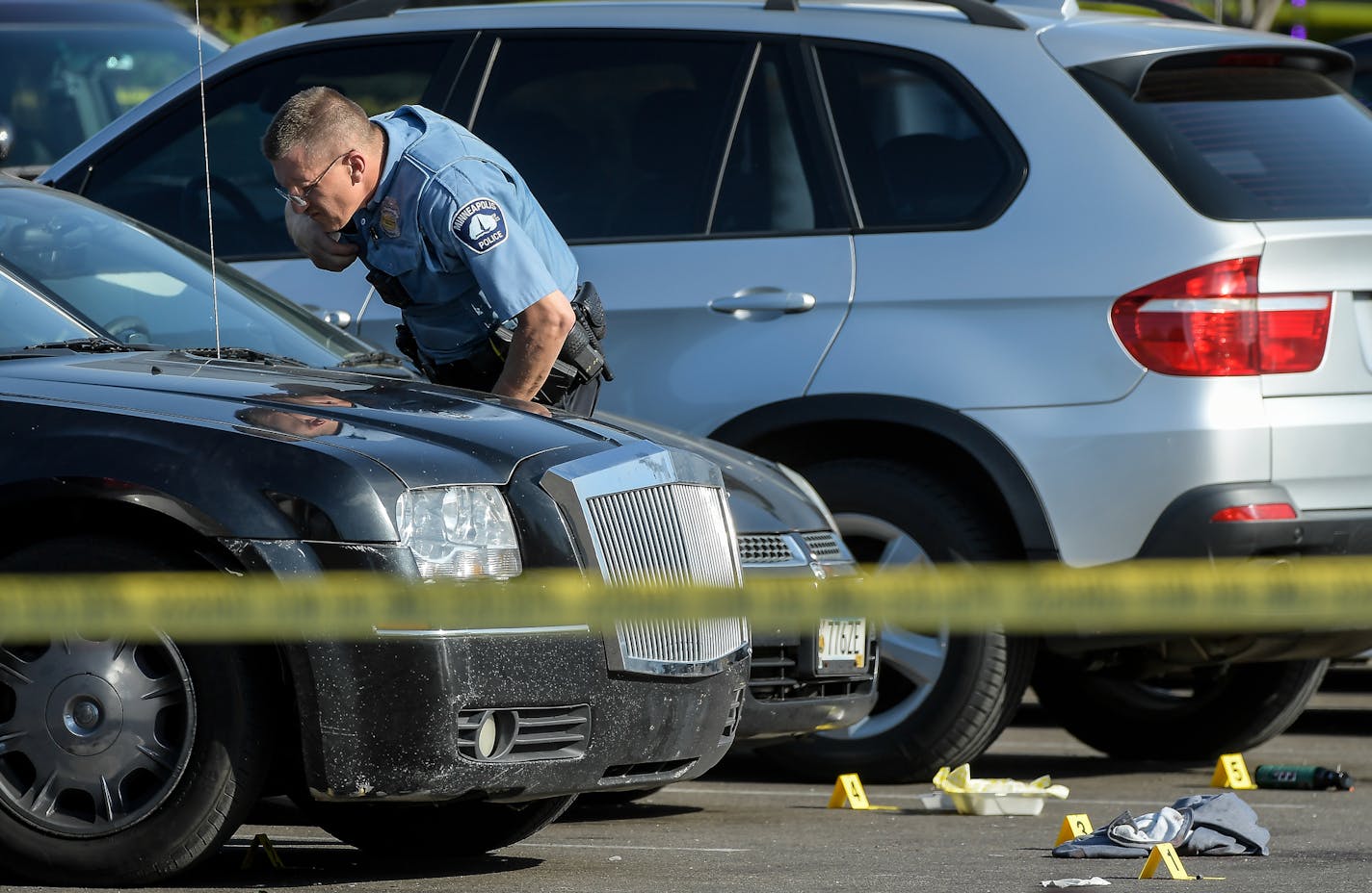 A Minneapolis Police officer peered through the windshield of a car at the scene of a homicide Friday on the 600 block of Broadway Avenue West. ] AARON LAVINSKY &#xef; aaron.lavinsky@startribune.com Minneapolis Police investigate the scene of a homicide in a strip mall on the 600 block of Broadway Avenue West in Minneapolis on Friday, May 12, 2017.