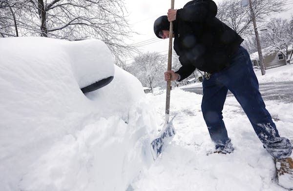 Joe Trusty clears snow from his car parked along street near his home on Friday, Feb. 24, 2017, in Rochester, Minn. Forecasters expected additional sn