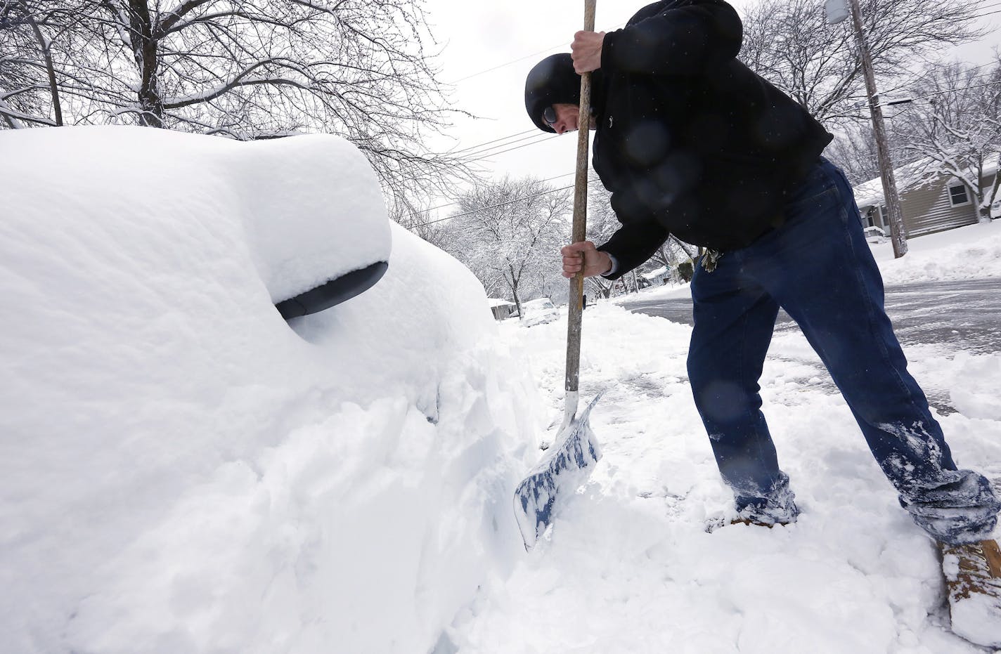 Joe Trusty clears snow from his car parked along street near his home on Friday, Feb. 24, 2017, in Rochester, Minn. Forecasters expected additional snow through Friday night. The heavy snow missed the Twin Cities in Minnesota and the Milwaukee metro area in Wisconsin. (Andrew Link/The Rochester Post-Bulletin via AP)