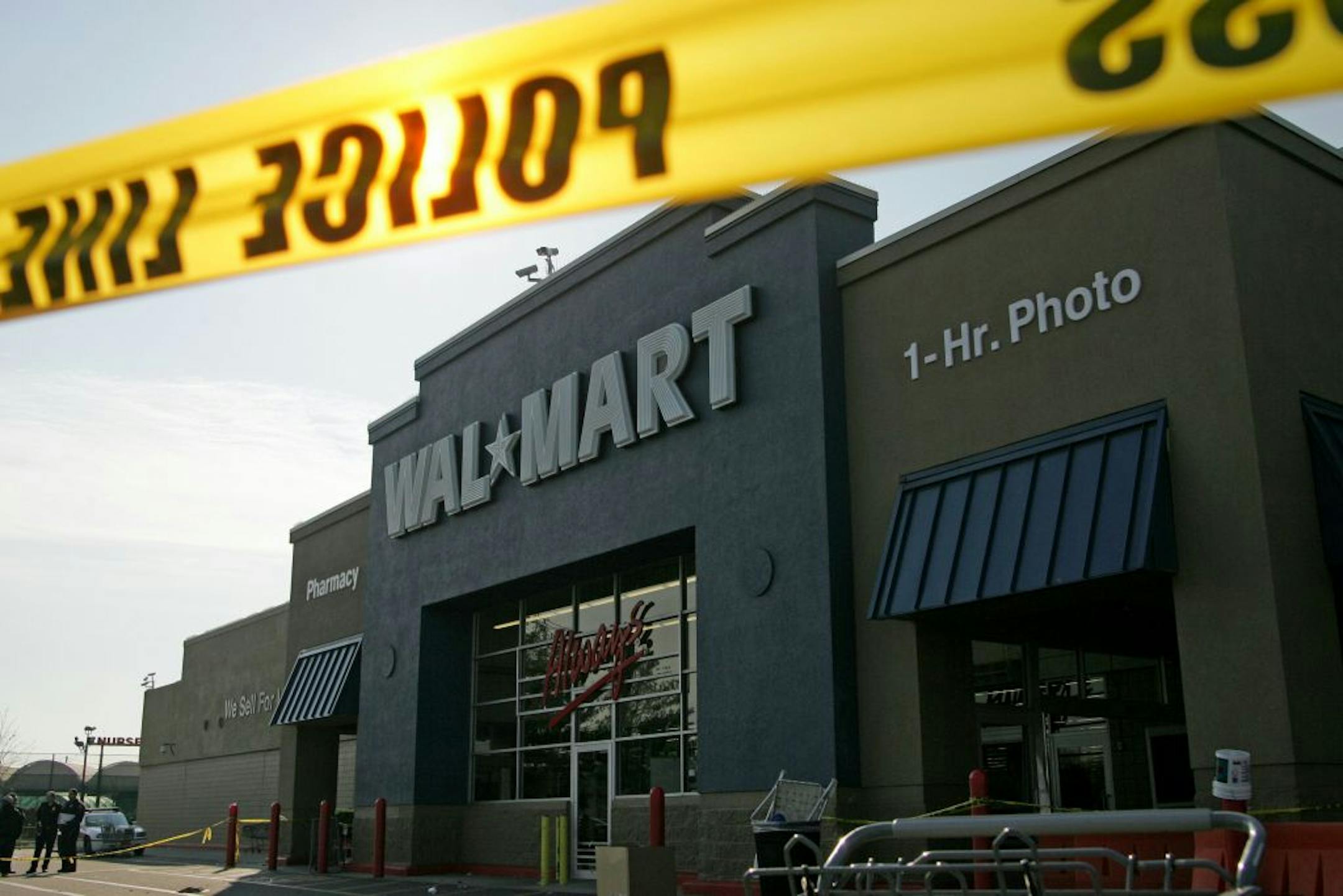 Nassau County Police examine the front of the Wal-Mart in Valley Stream, N.Y., Friday, Nov. 28, 2008, after a temporary Wal-Mart worker died after a throng of eager shoppers broke down the doors and trampled him moments after the Long Island store opened early Friday for day-after-Thanksgiving bargain hunting, police said.