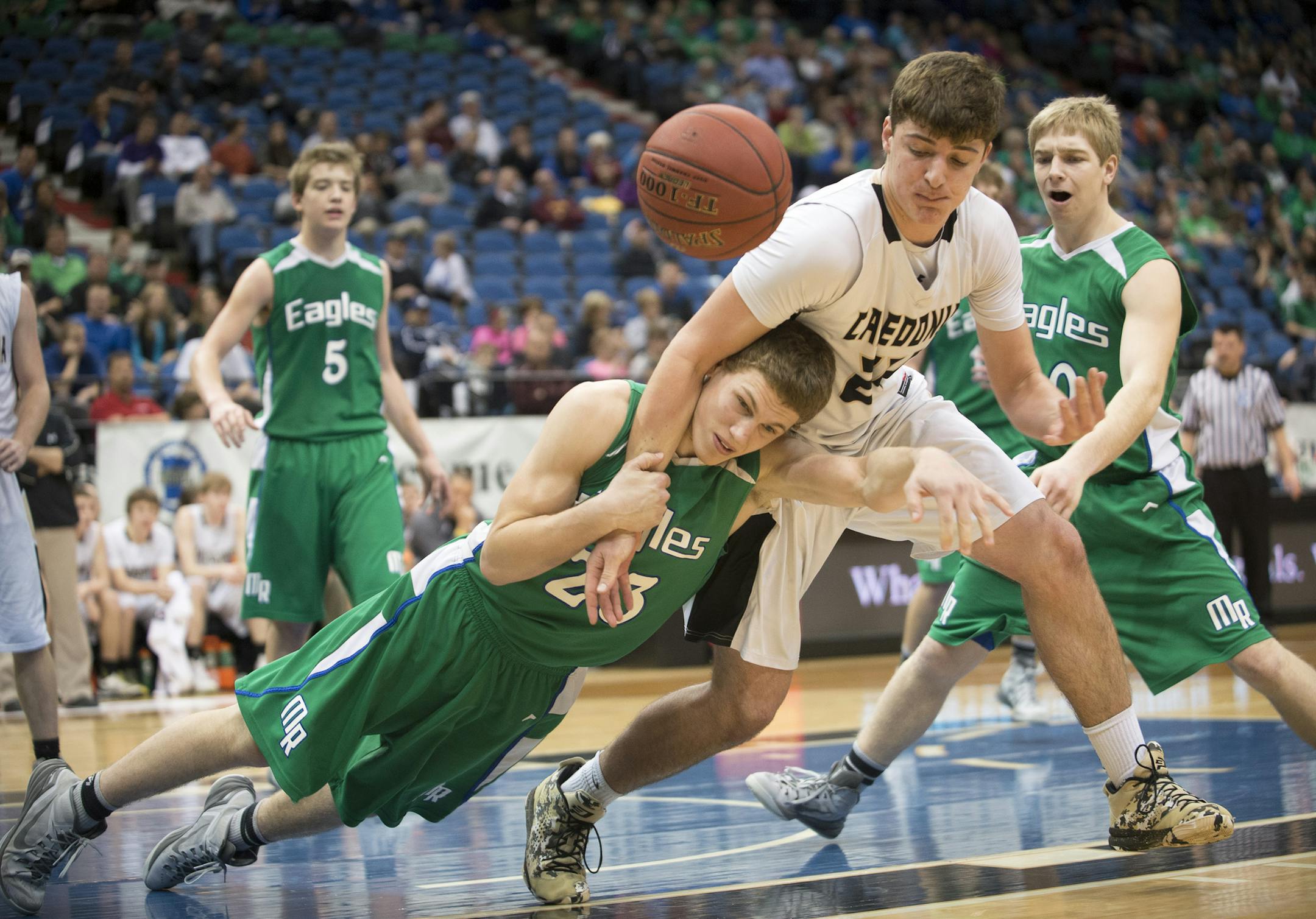 Maple River center Grant Sonnek (23) fouls Caledonia forward Justin Burg (24) during a physical rebound in the second half. ] (Aaron Lavinsky | StarTribune) Caledonia plays against Maple River in the Class 2A boys' basketball semifinals on Friday, March 13, 2015 at Target center.