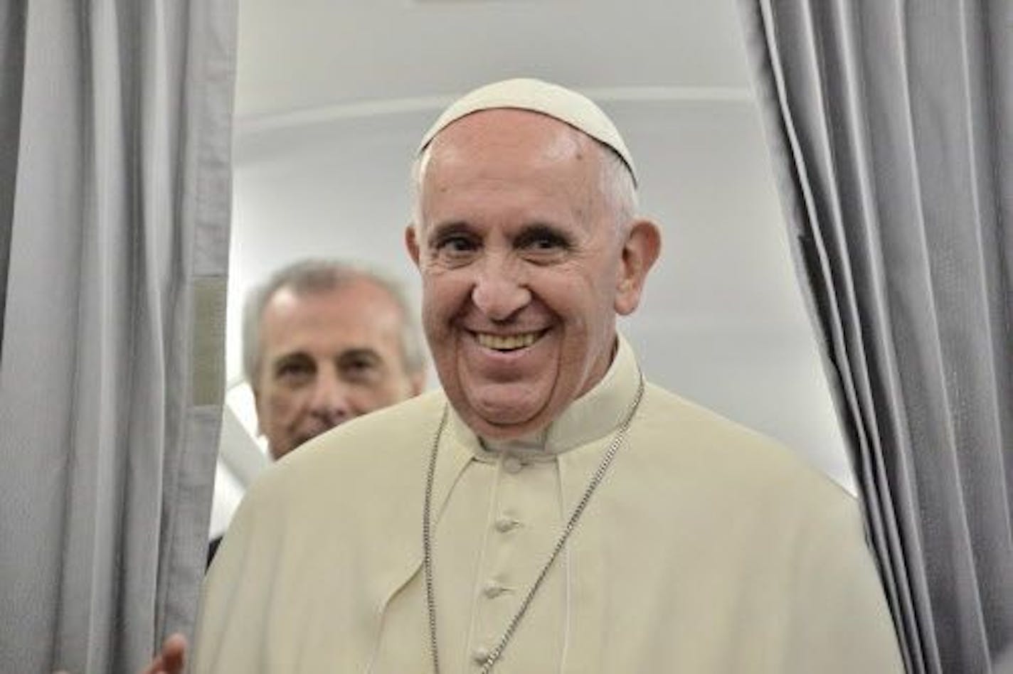 Pope Frances smiles as he talks to the media on board of an airplane on his way to Rome, after a one-day visit to Sarajevo, Saturday, June 6, 2015.