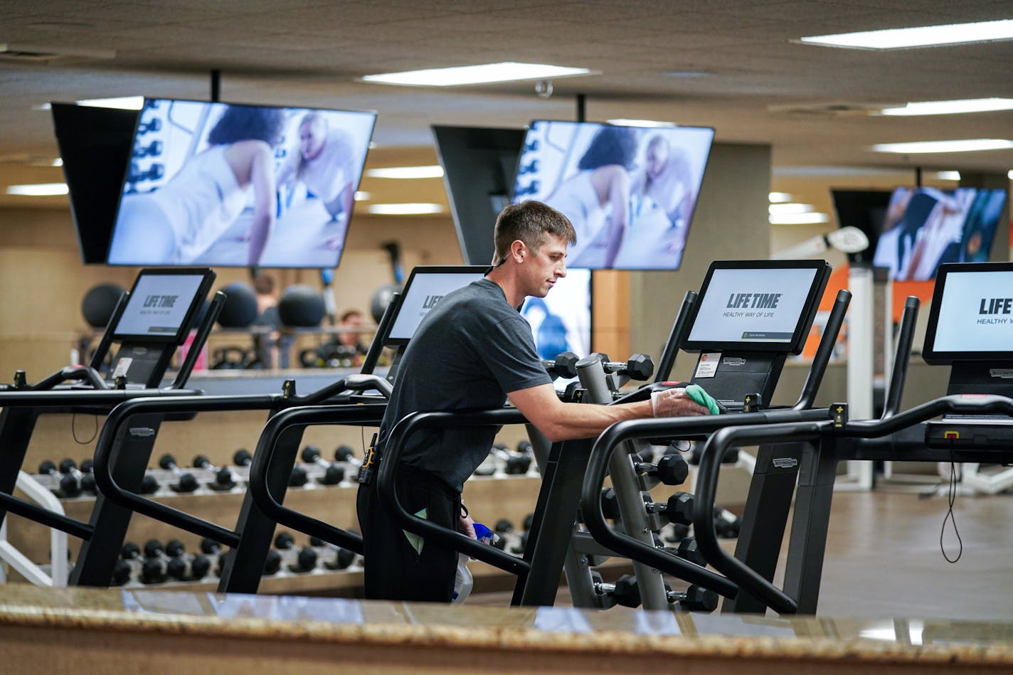 Bradley Carr cleaned exercise equipment at a Life Time health club with Purell surface disinfectant in March.