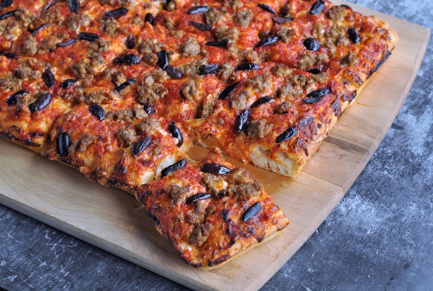 Spicy Sausage and Kalamata Slab Pizza has a focaccia-like crust. Meredith Deeds, Special to the Star Tribune