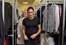 Meghan, the Duchess of Sussex, accompanied by Juliet Hughes-Hallett, as they walk past racks of clothes at the Smart Works charity career centre in We