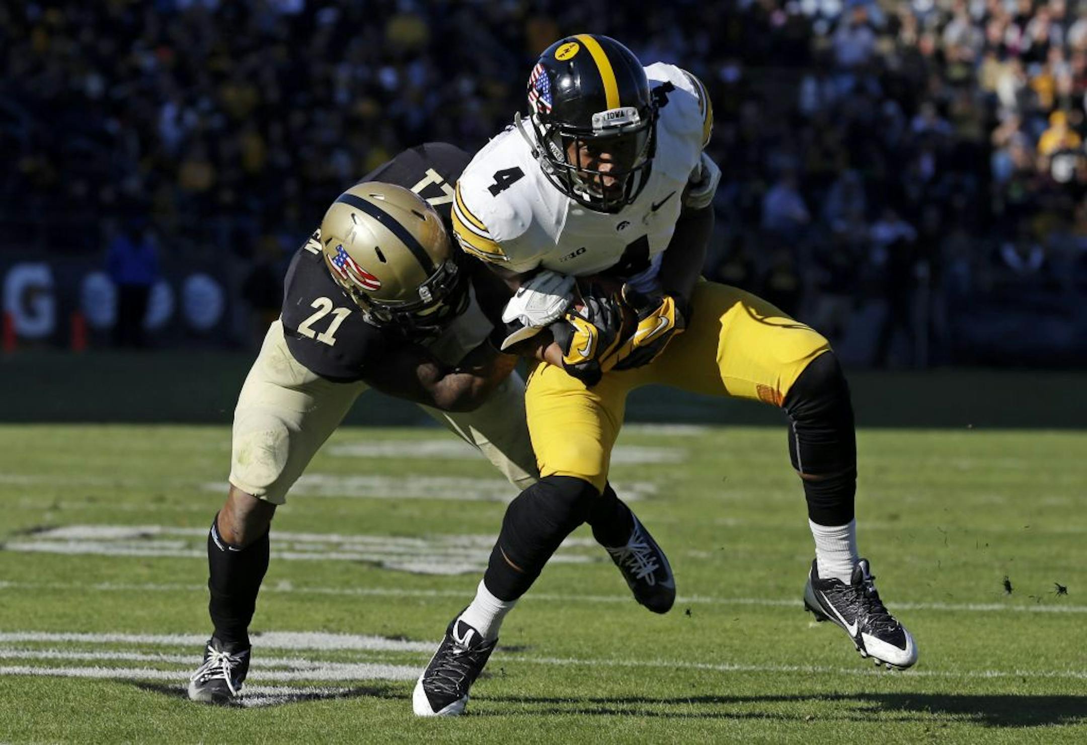 Iowa wide receiver Tevaun Smith, right, is hit by Purdue cornerback Ricardo Allen after a 6-yard gain during the second half of an NCAA college football game in West Lafayette, Ind., Saturday, Nov. 9, 2013. Iowa defeated Purdue 38-14.