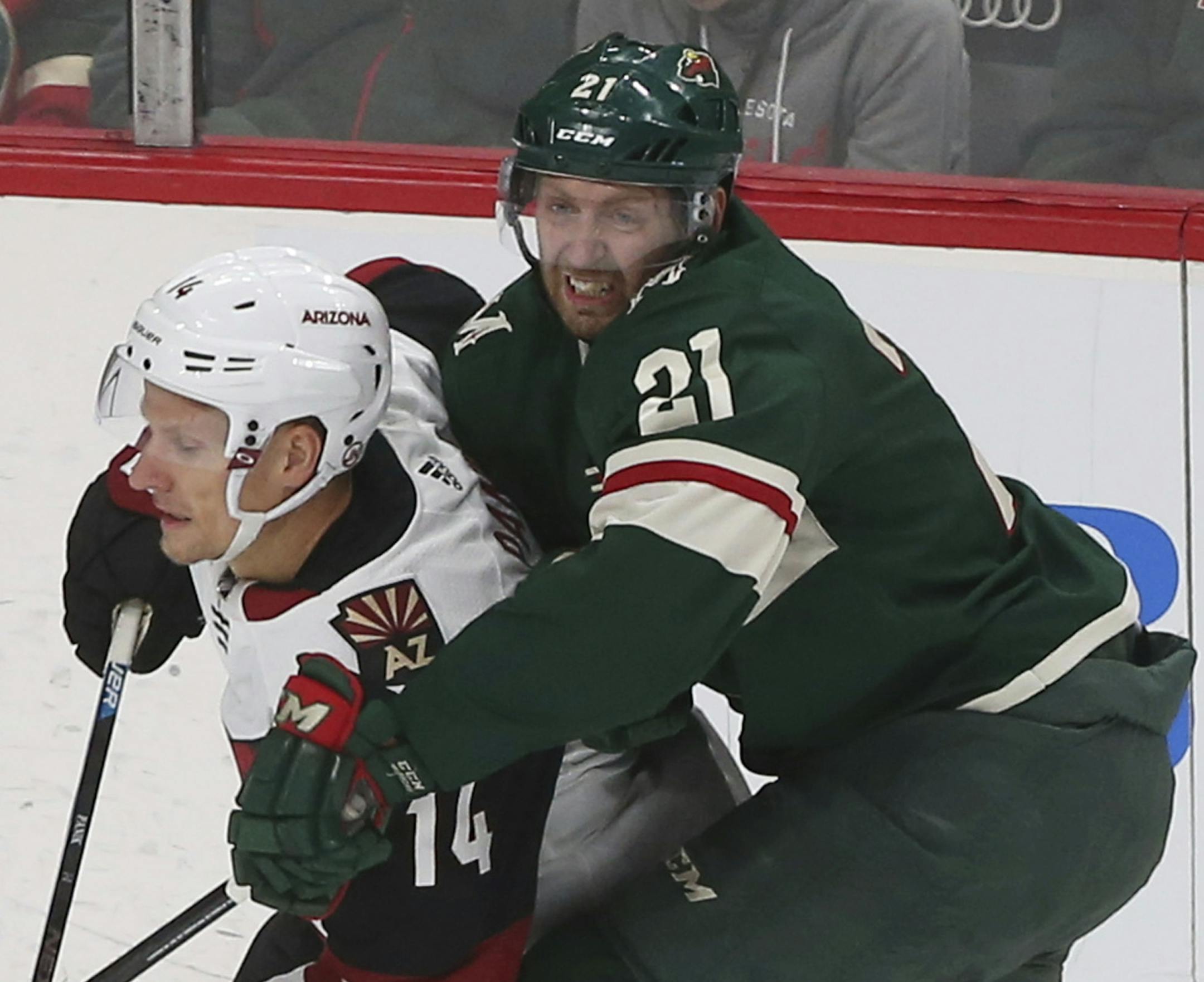 Minnesota Wild's Eric Fehr, right, hangs onto Arizona Coyotes' Richard Panik of Slovakia in the first period of an NHL hockey game Tuesday, Oct. 16, 2018, in St. Paul, Minn. (AP Photo/Jim Mone)