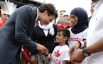 Prime Minister Justin Trudeau greets members of a Syrian refugee family during Canada Day celebrations on Parliament Hill, in Ottawa on Friday, July 1